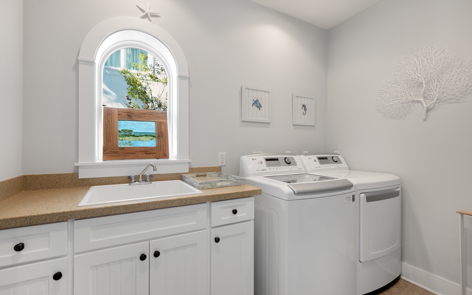 Your laundry routine becomes effortless with modern appliances and a charming arched window brightening this thoughtfully designed space.