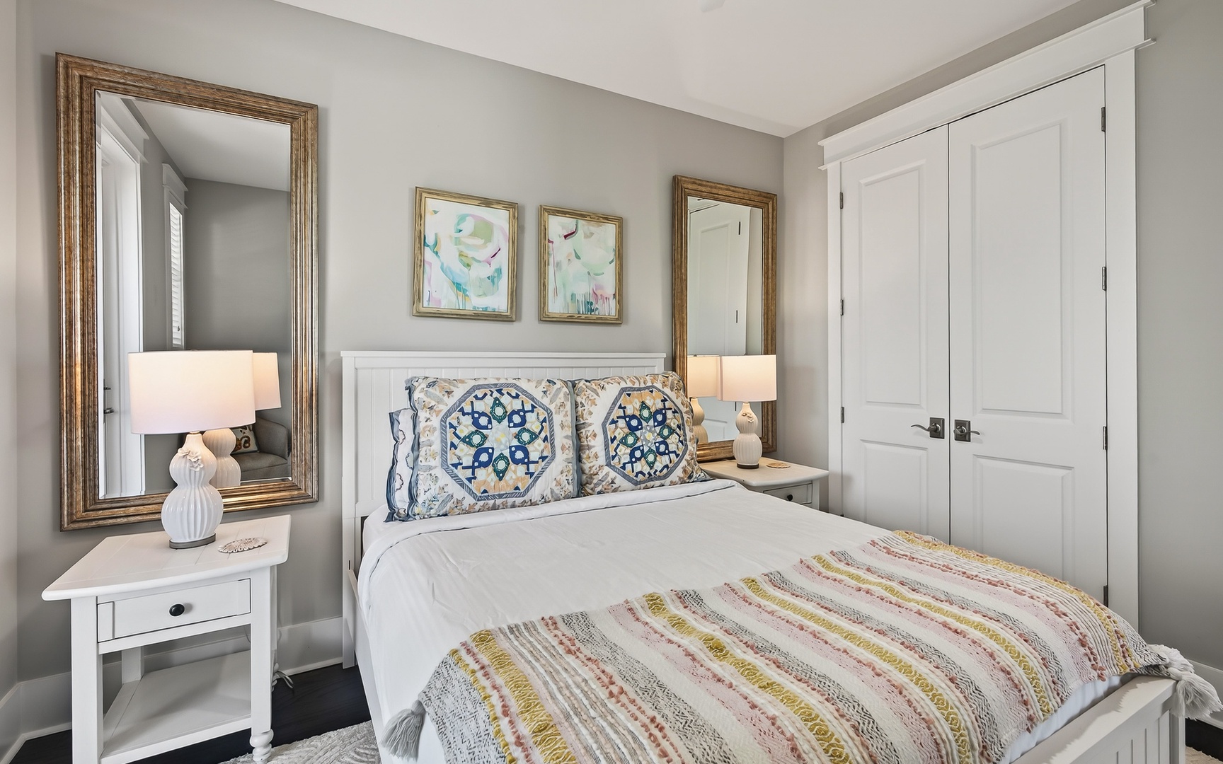 Sink into crisp white linens and colorful Mediterranean patterns in your serene bedroom retreat, complete with thoughtful touches and elegant storage.