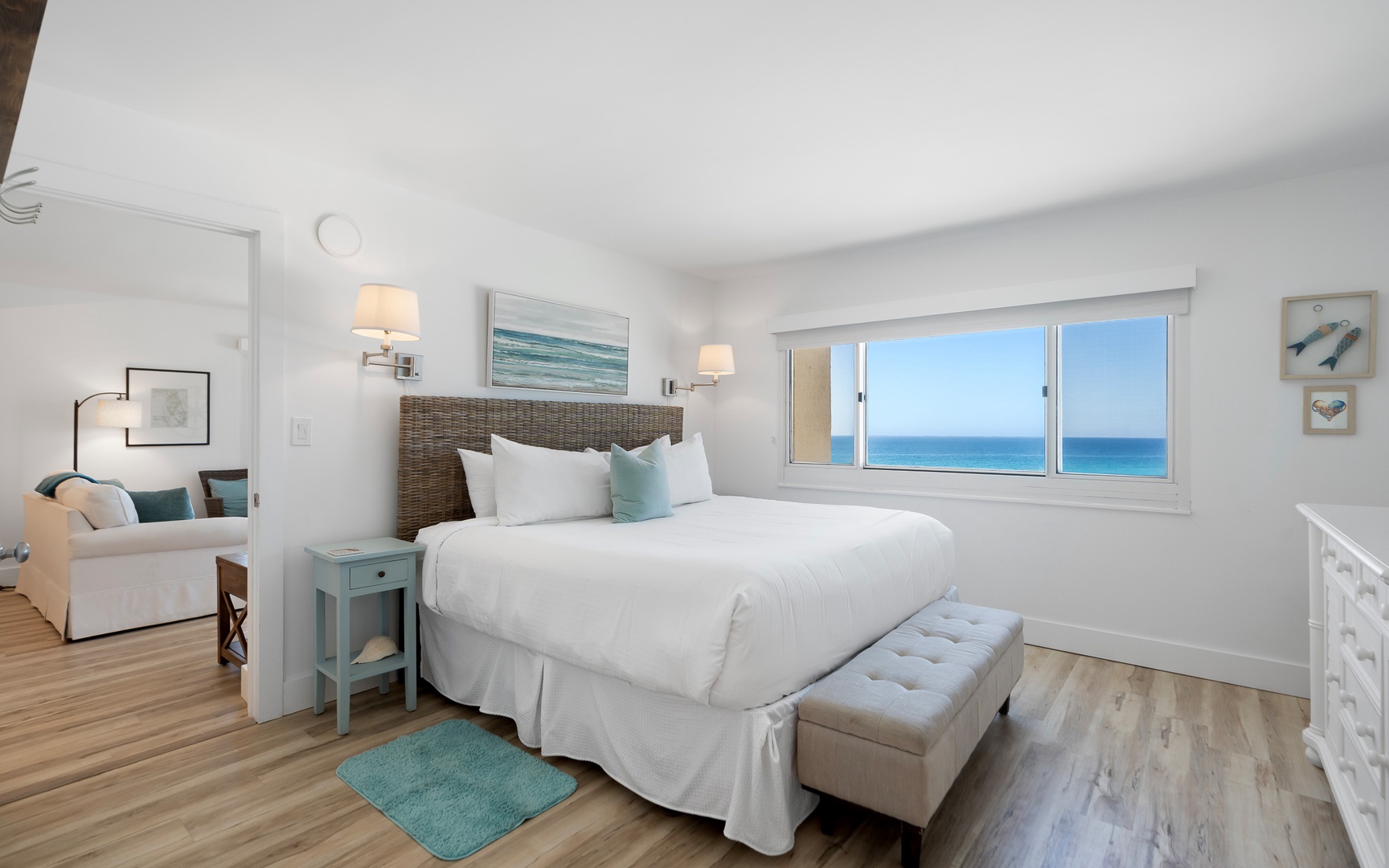 Wake up to stunning ocean views through your bedroom window, where crisp white linens and coastal decor create the perfect seaside retreat.