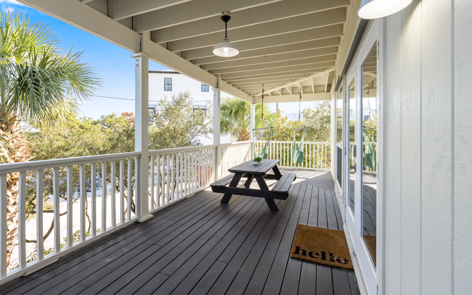 Your private covered balcony invites peaceful mornings with coffee at the picnic table, surrounded by tropical palm views.