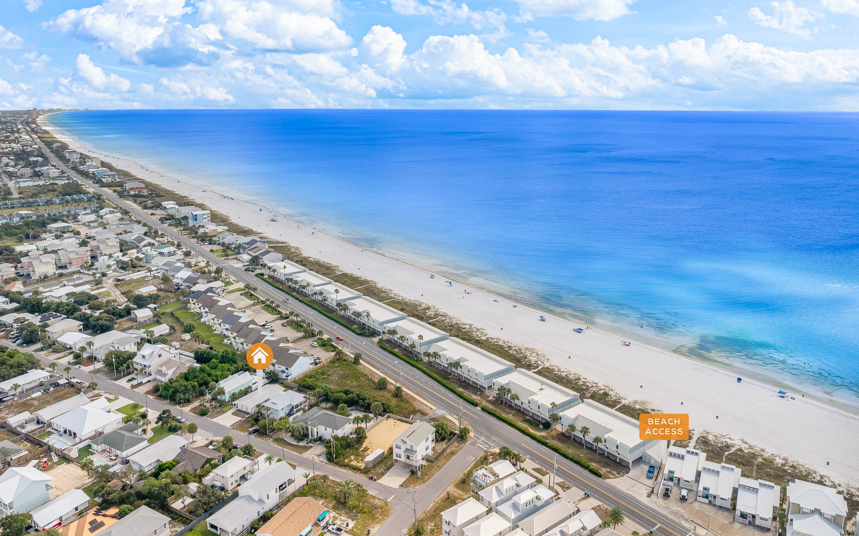 Aerial view of beachfront community with pristine white sand beach and crystal-clear turquoise waters stretching to the horizon.