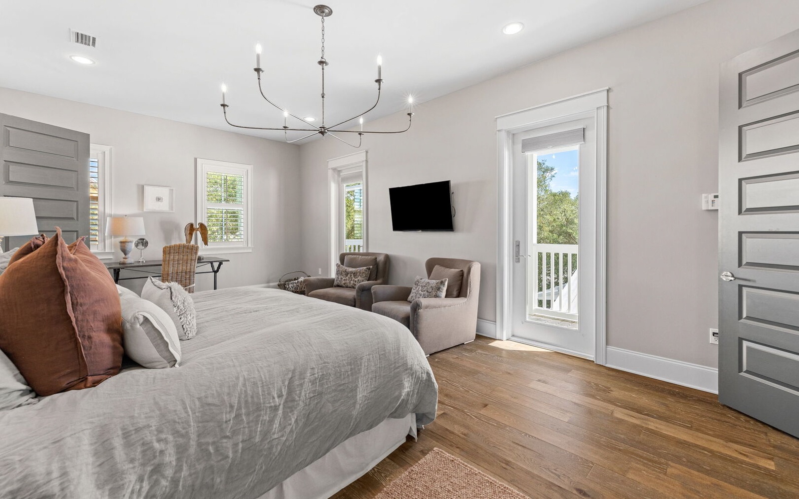 Drift into peaceful sleep in your elegant bedroom, complete with comfortable seating and private balcony access overlooking serene treetops.