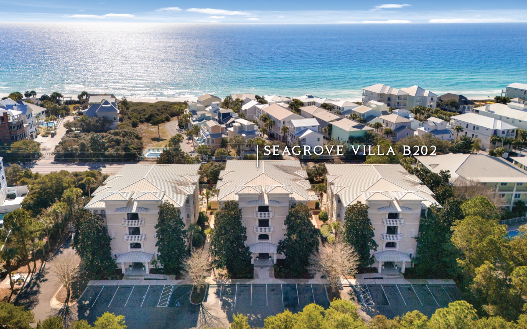 Aerial view of beachfront vacation rentals nestled among lush greenery, just steps from pristine white sand beaches and sparkling Gulf waters.