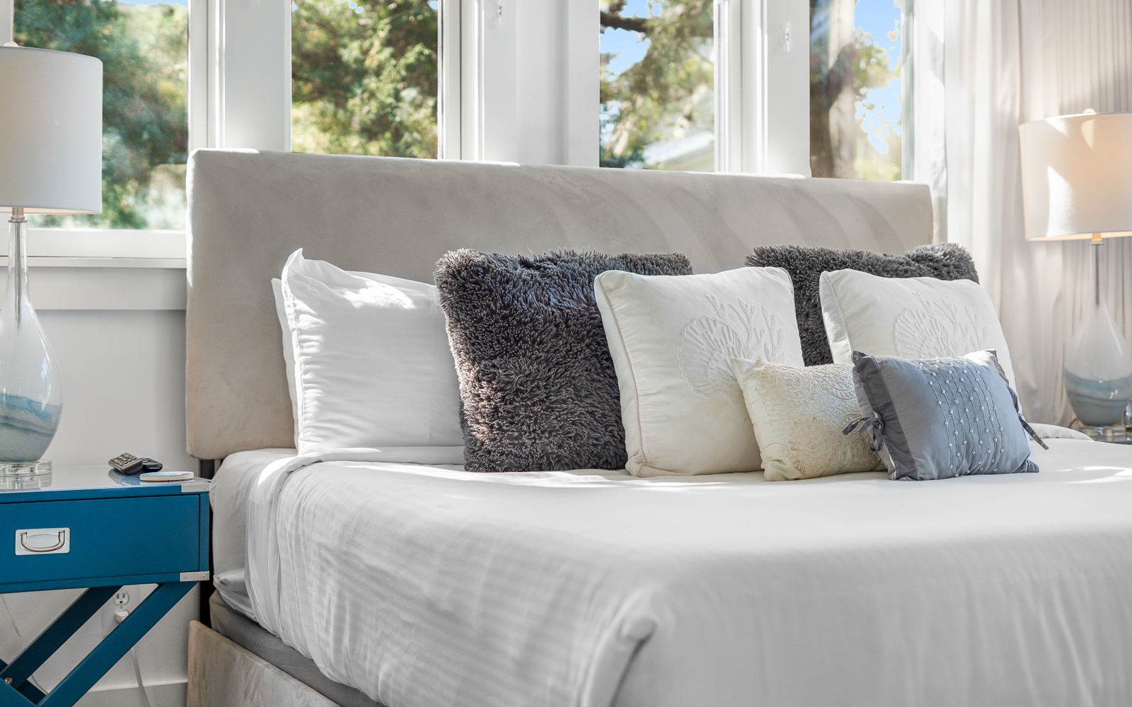 Sink into crisp white linens and plush pillows while natural light filters through your bright windows.