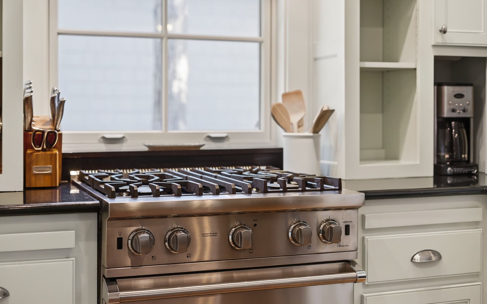 Cook your favorite meals on this professional-grade gas range with sleek stainless steel finish and modern white cabinetry.