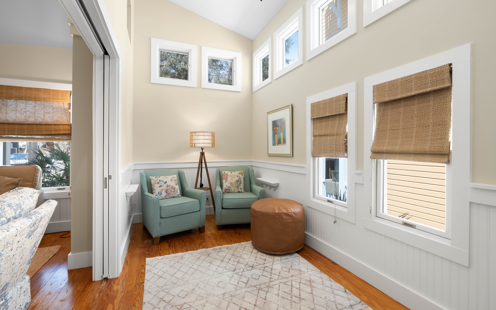 Sink into these plush chairs by the window, where natural light streams through bamboo shades and creates your perfect reading nook.