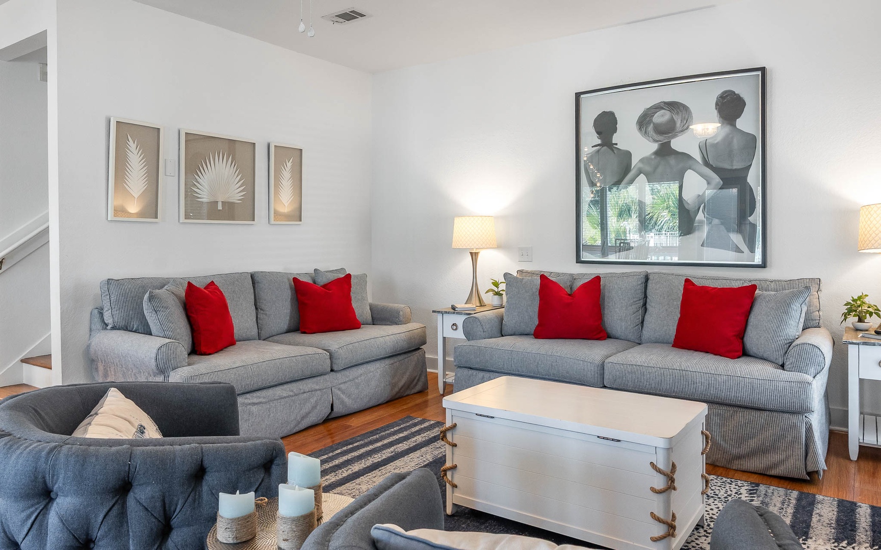 Settle into your stylish living room with plush gray sofas and bright red pillows. Natural light streams in as you relax in this thoughtfully designed space.