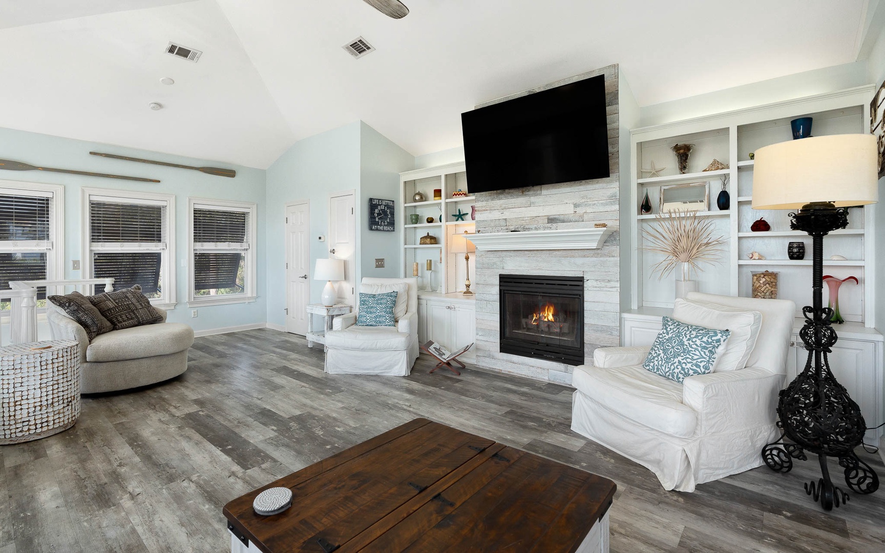 Sink into plush seating beside your crackling fireplace, where built-in shelving displays your treasures and soft lighting creates the perfect ambiance.