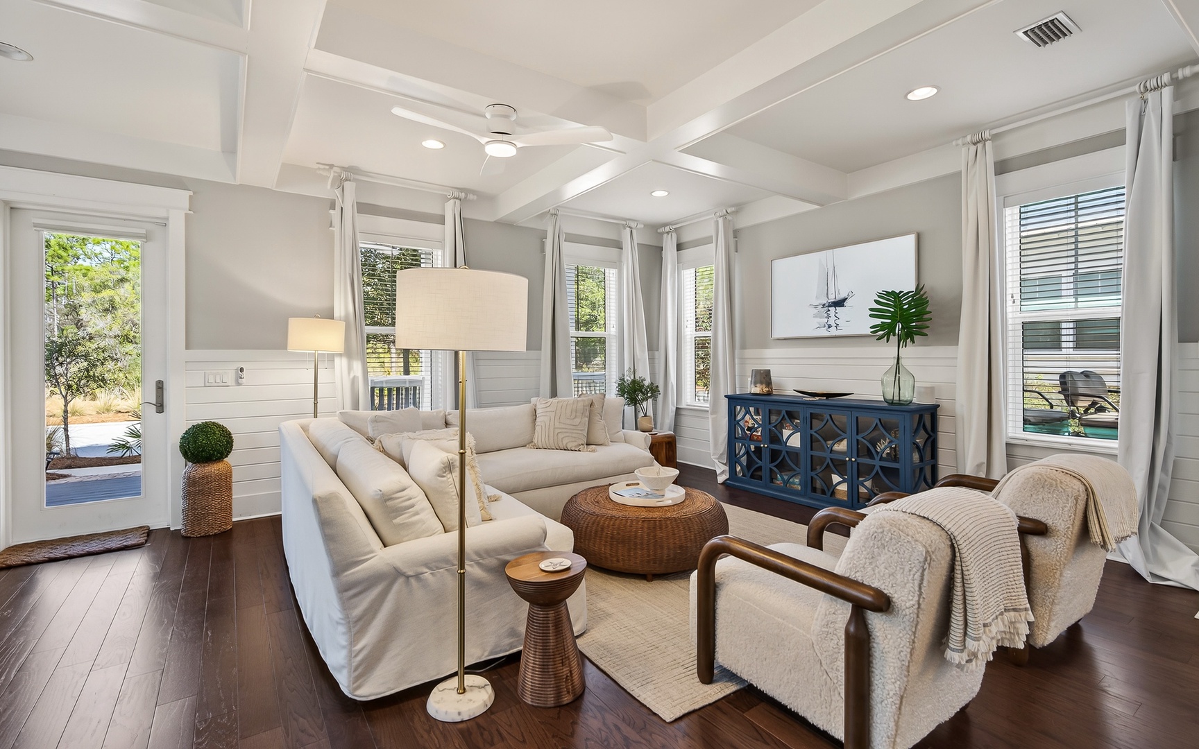 Sink into the plush sectional sofa where coffered ceilings and abundant natural light create your perfect retreat.