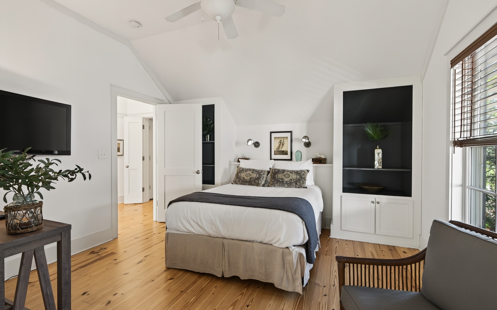 Relax in your bright, airy bedroom featuring warm hardwood floors, built-in storage, and thoughtful touches that make this space feel like home.