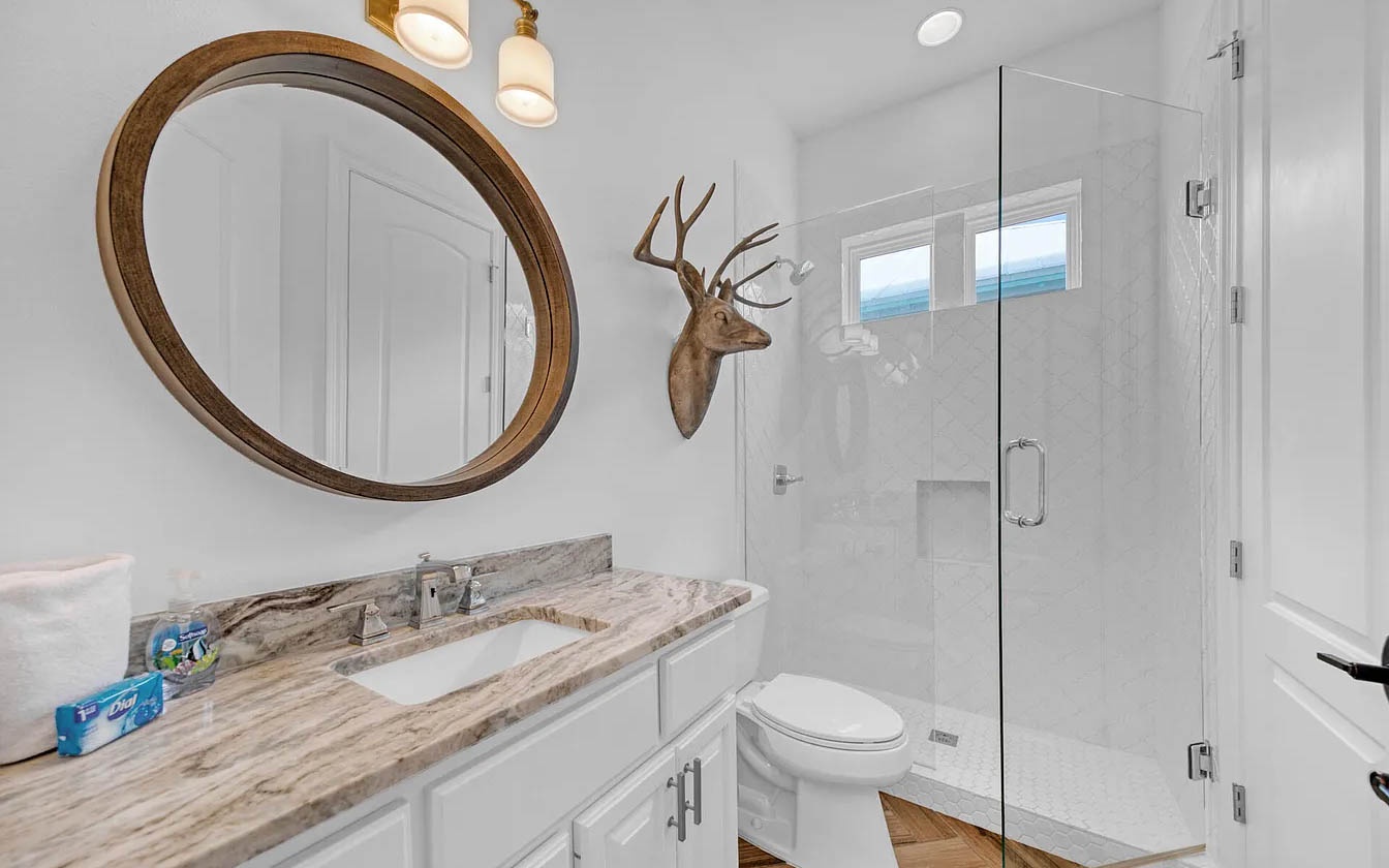 Freshen up in your beautifully appointed bathroom, featuring elegant marble counters, a spacious glass shower, and charming rustic touches.