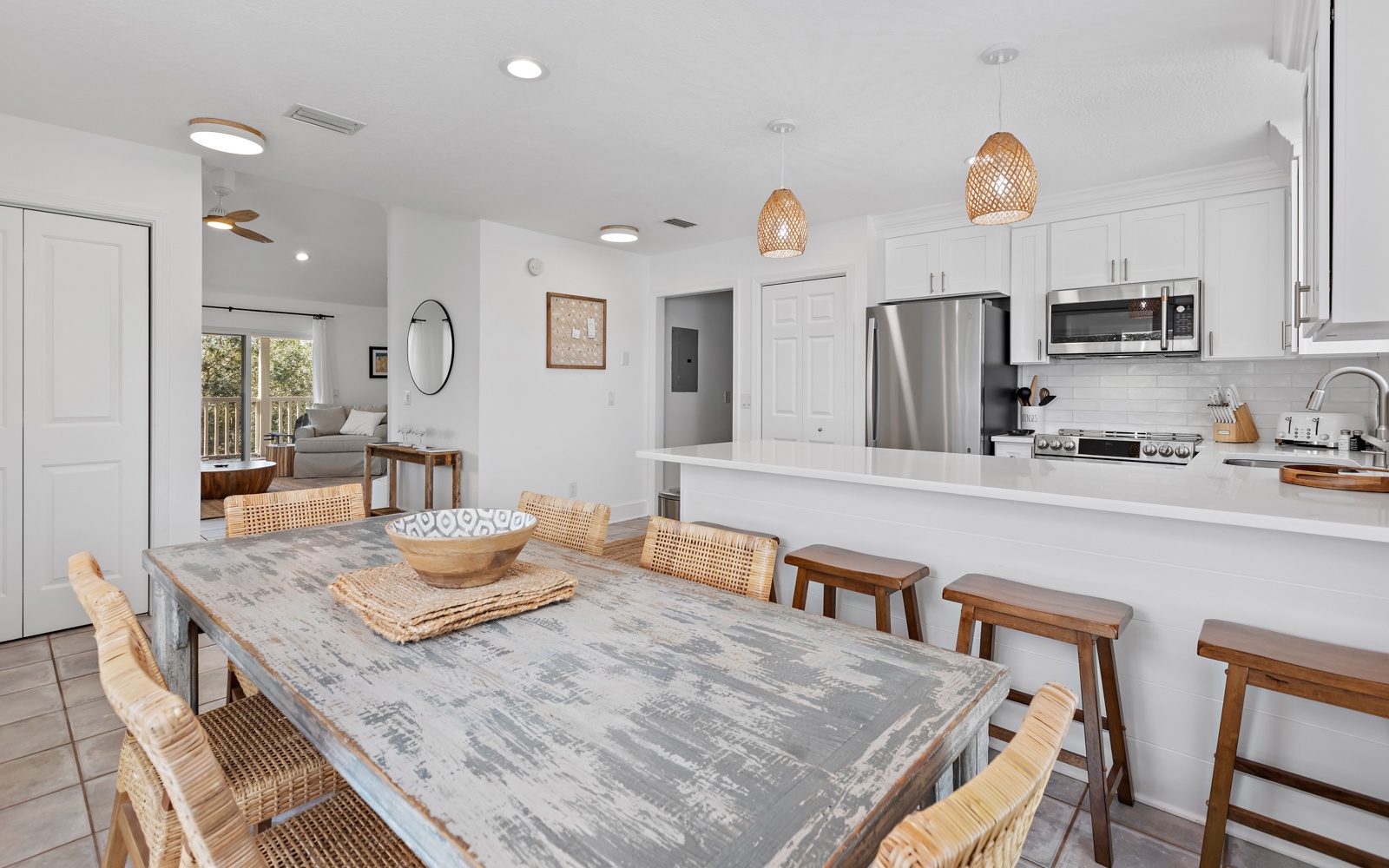 Your open-concept kitchen and dining area blends modern convenience with warm coastal charm, perfect for gathering with loved ones.