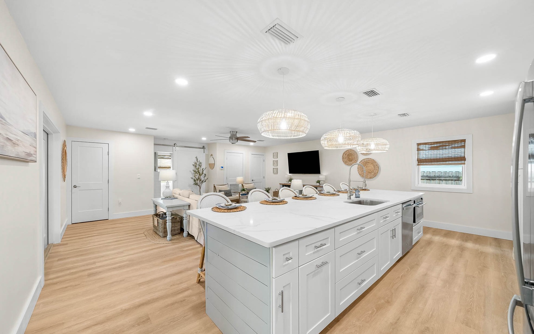 Your culinary dreams come alive in this bright open kitchen with gleaming counters, pendant lights, and seamless flow to the living area.