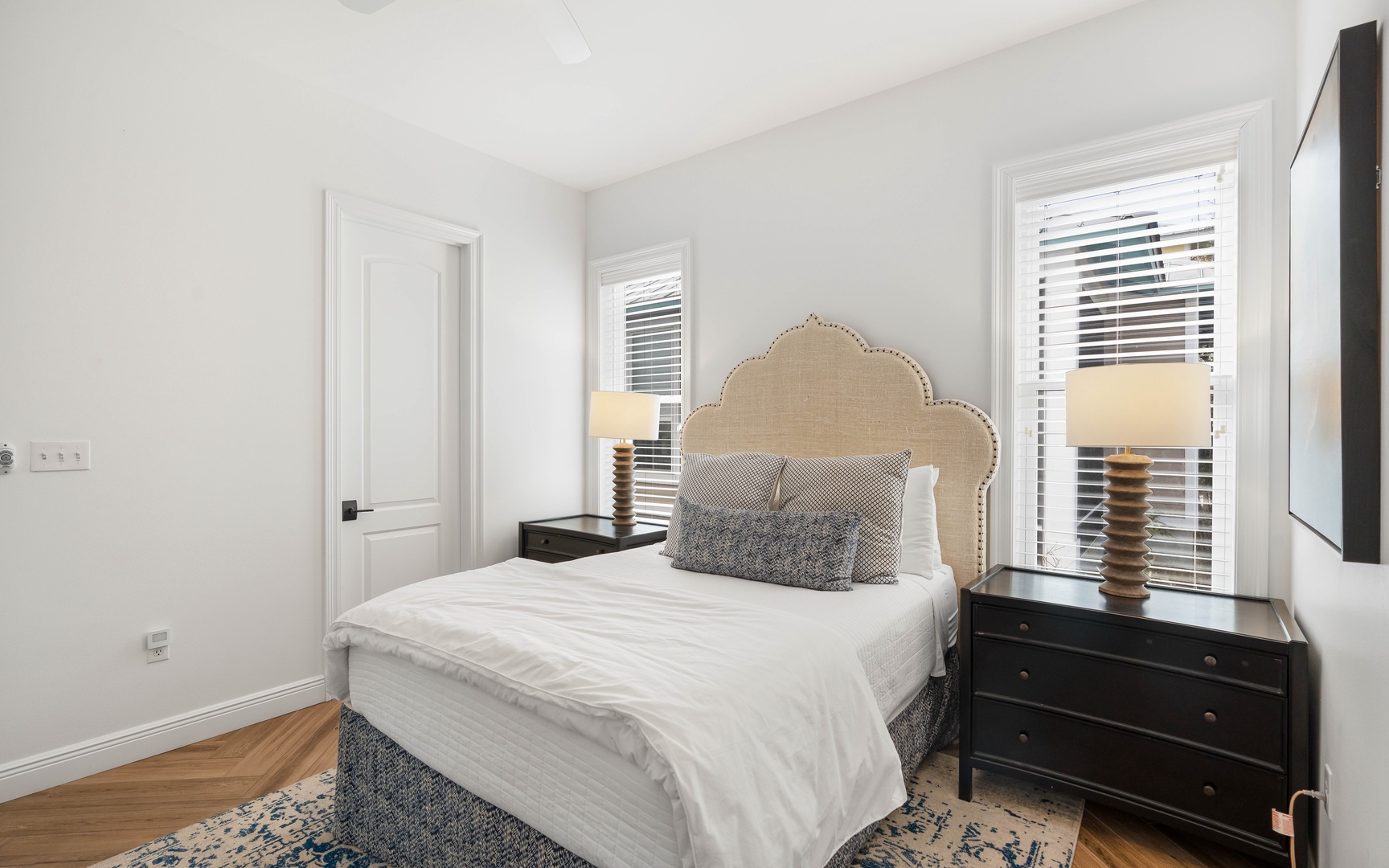 Drift off in this elegant bedroom with plush linens, warm wood floors, and natural light streaming through your windows.