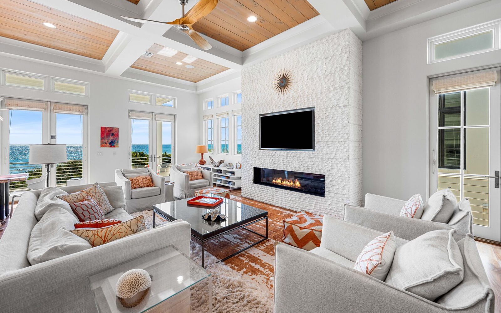 Unwind in this stunning living room where warm textures meet ocean views, complete with a cozy fireplace for evening ambiance.