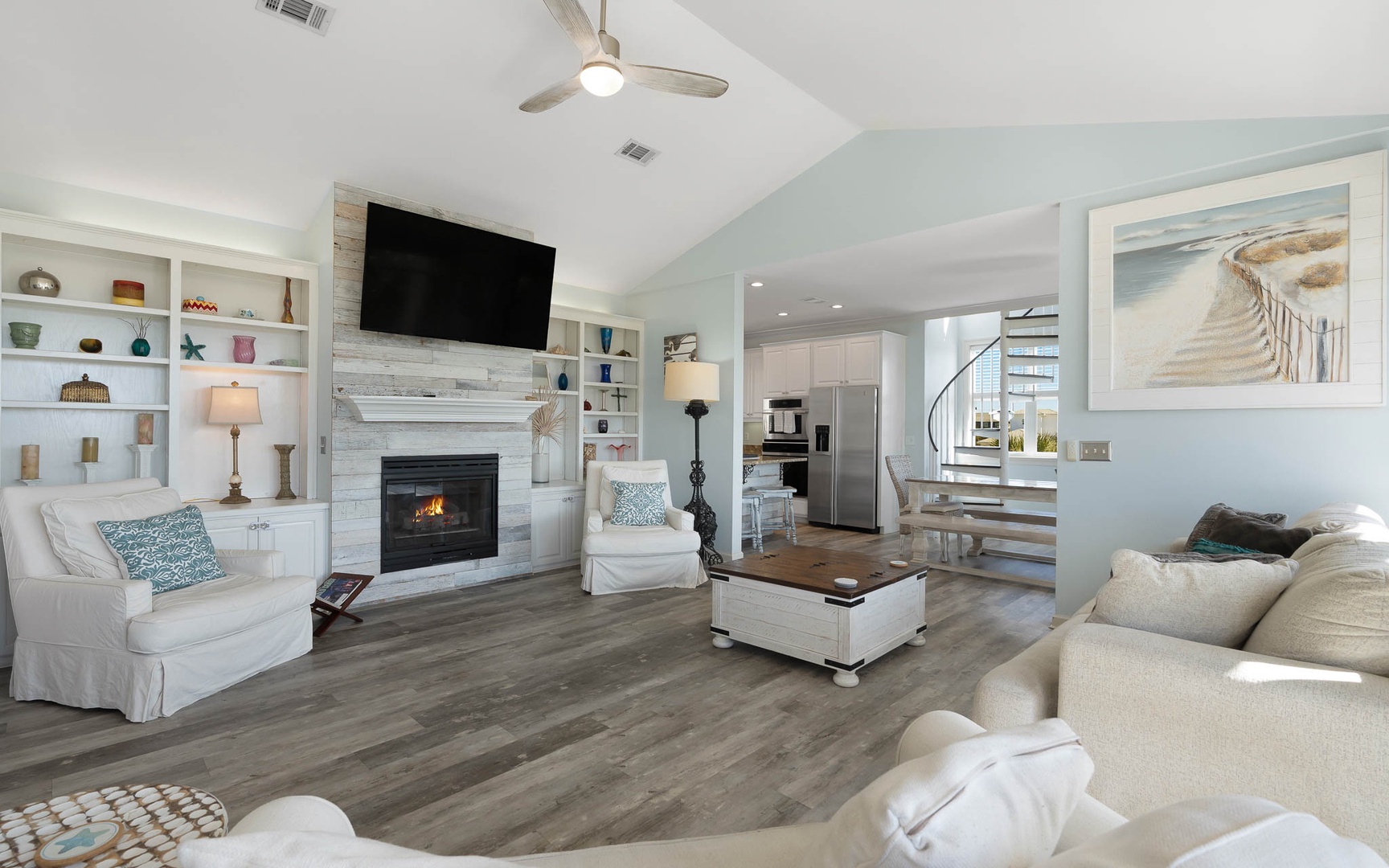 Unwind in your bright, open living space featuring a cozy fireplace, built-in shelving, and modern coastal touches that make you feel right at home.