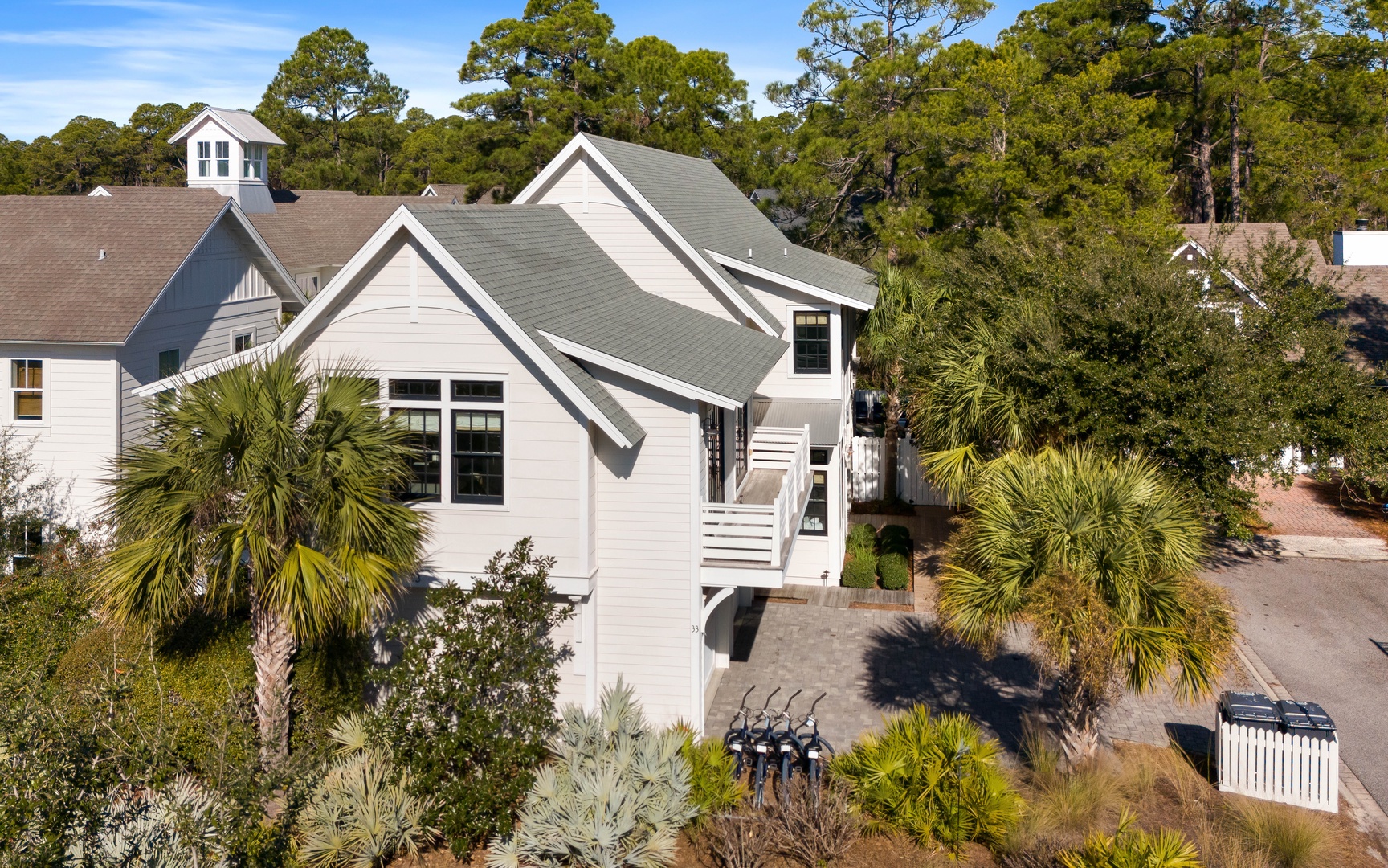 Coastal retreat surrounded by lush palmetto palms and mature trees in a peaceful residential setting.