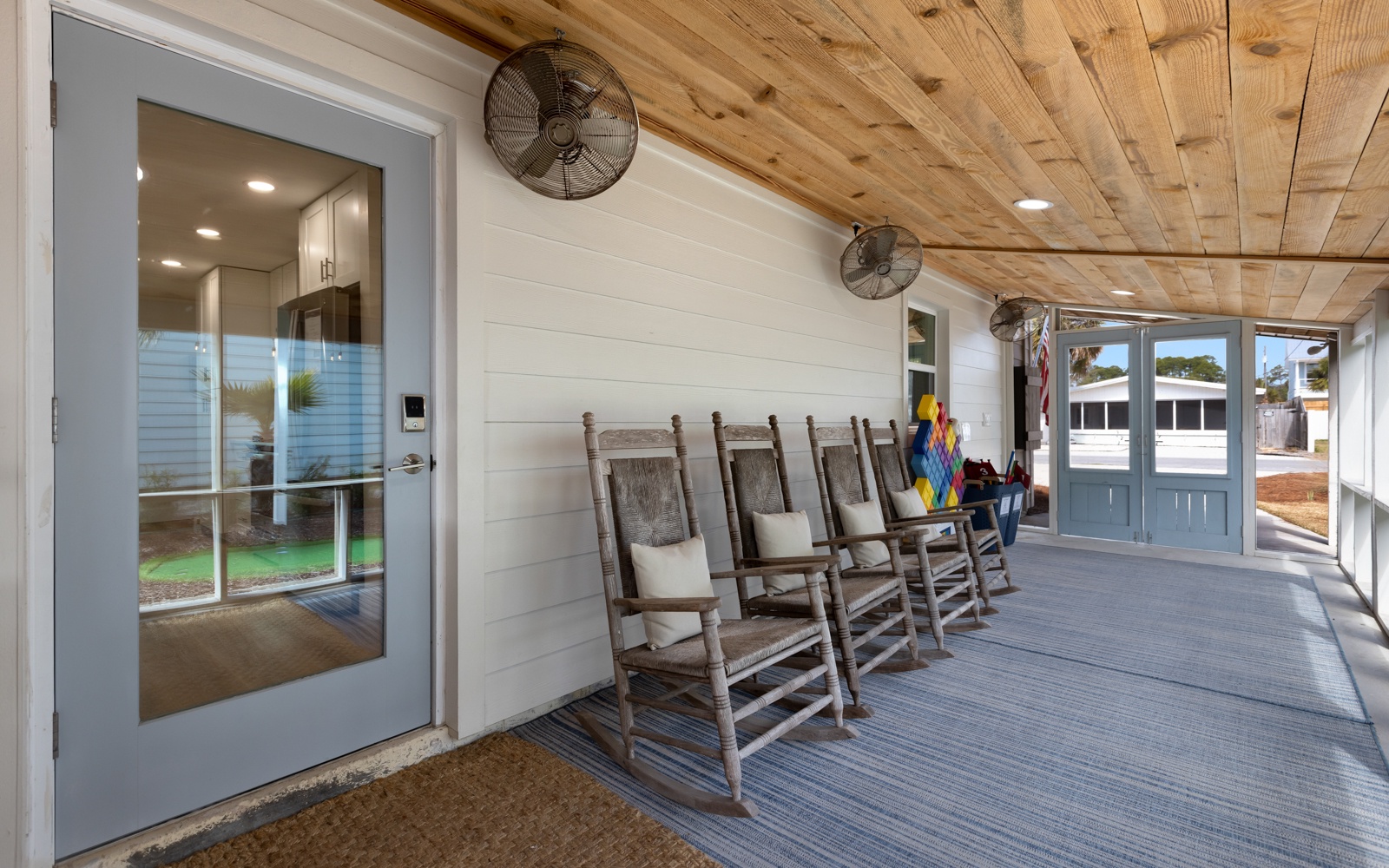 Unwind in your charming covered porch with rustic rocking chairs, where gentle ceiling fans create the perfect atmosphere for morning coffee or evening relaxation.
