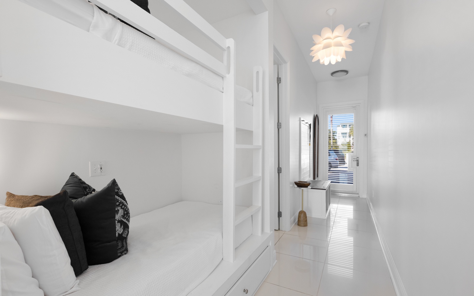 Drift off in this bright bedroom featuring custom bunk beds and stylish design touches that create a cozy retreat.