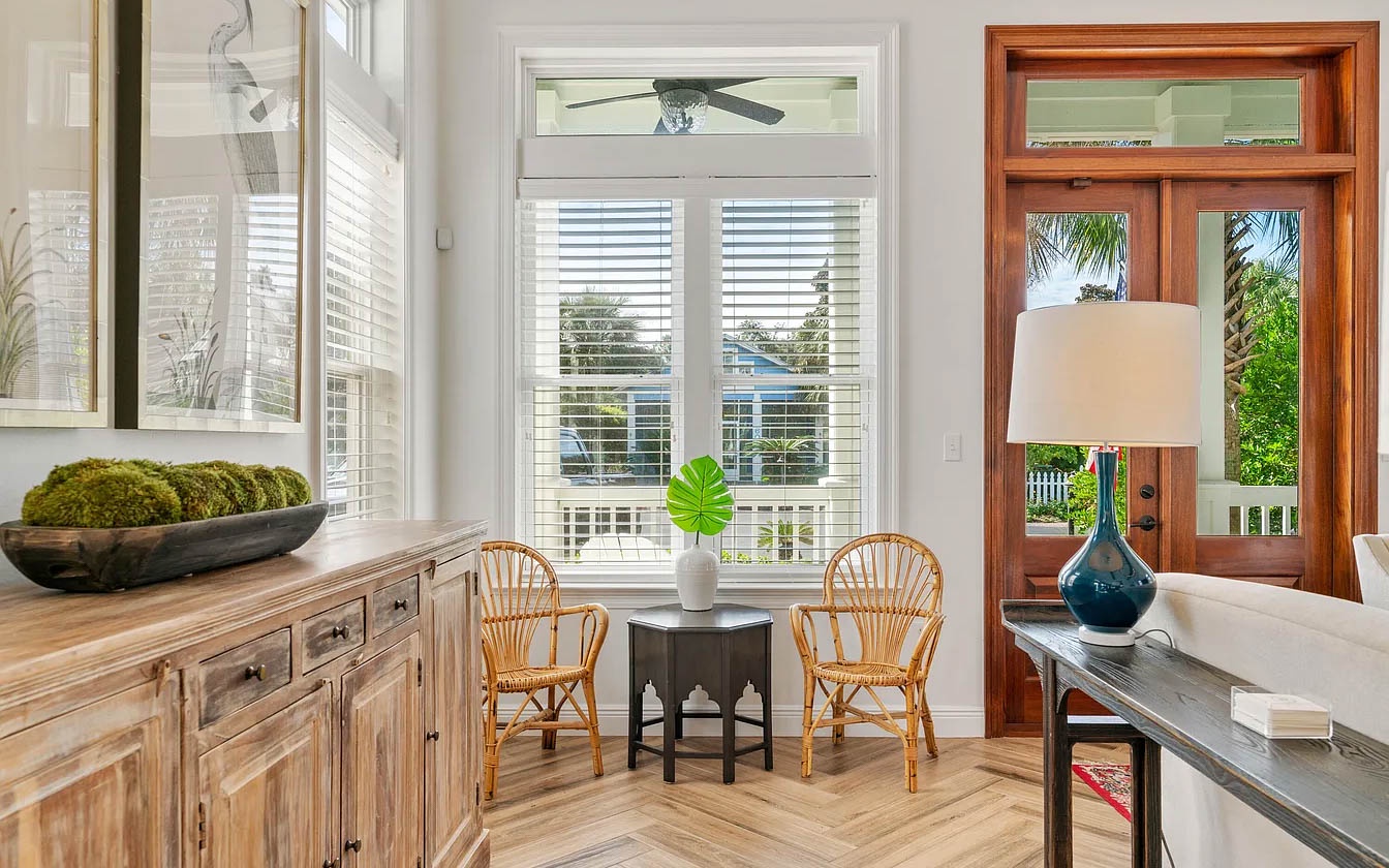 Bright living space with wicker seating and French doors opening to tropical views where you'll love relaxing.