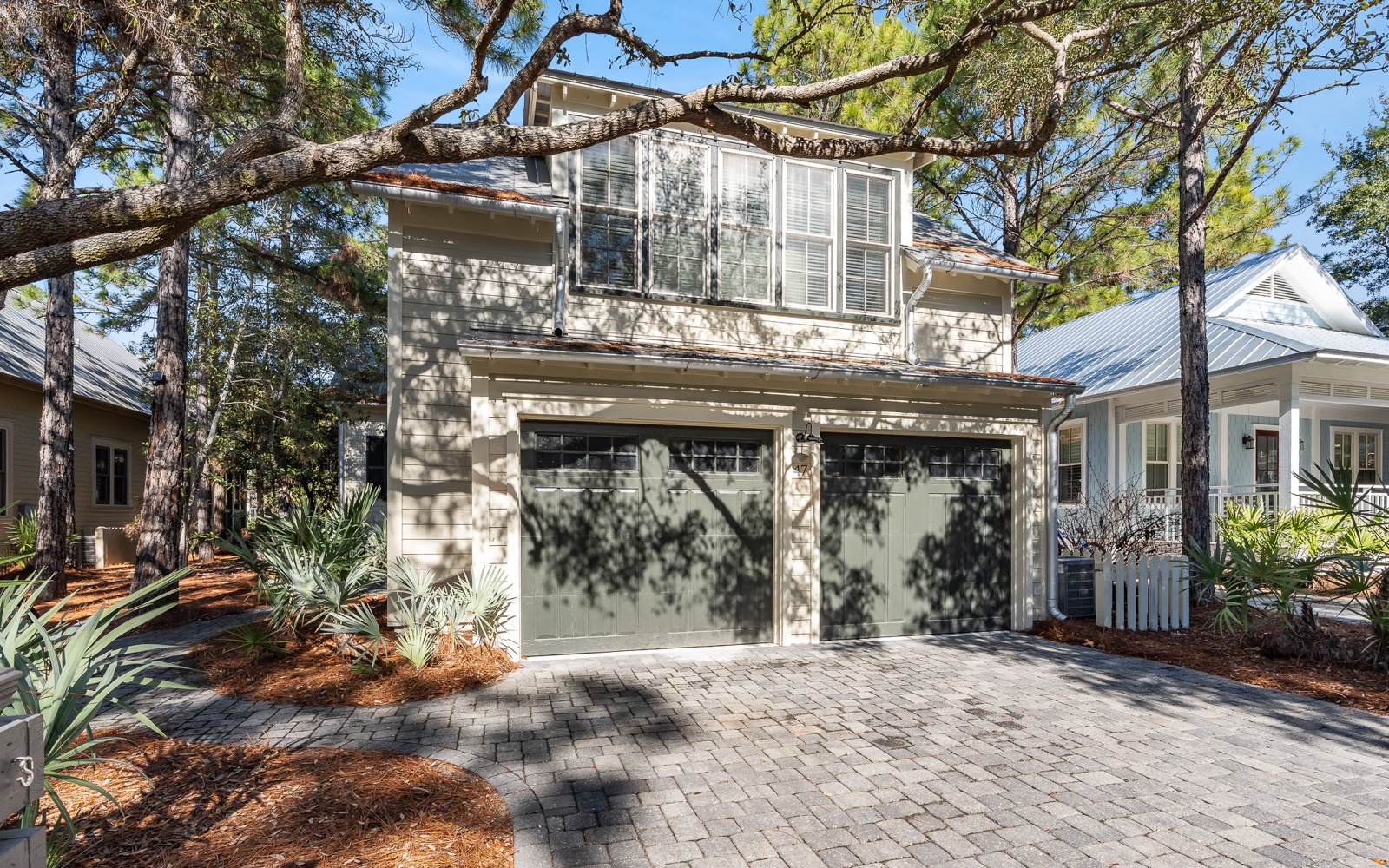 A charming coastal cottage nestled among mature trees with convenient garage parking and beautiful landscaped grounds.