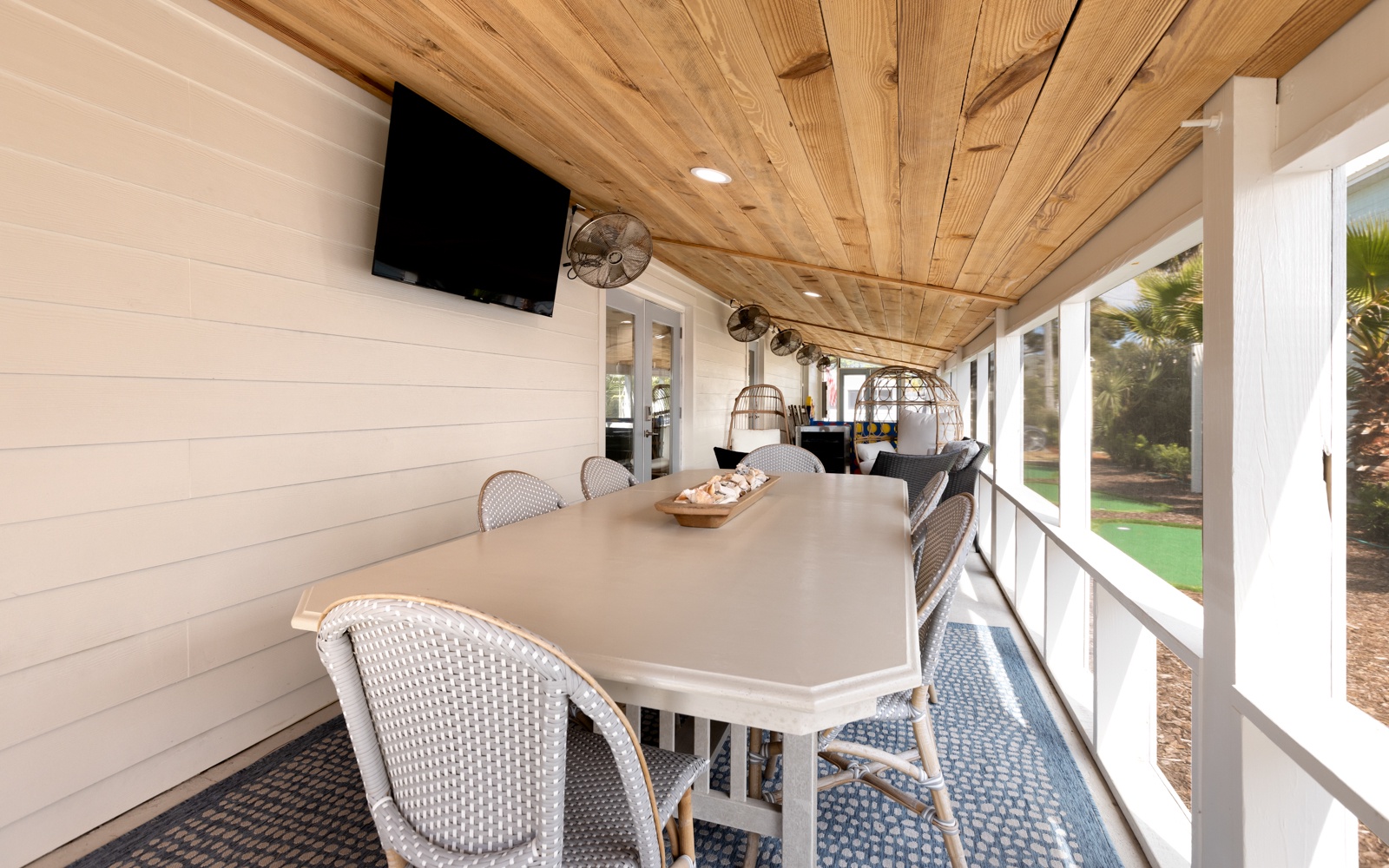 Gather around your private covered porch for meals under the warm wood ceiling, with garden views and entertainment ready for memorable moments.