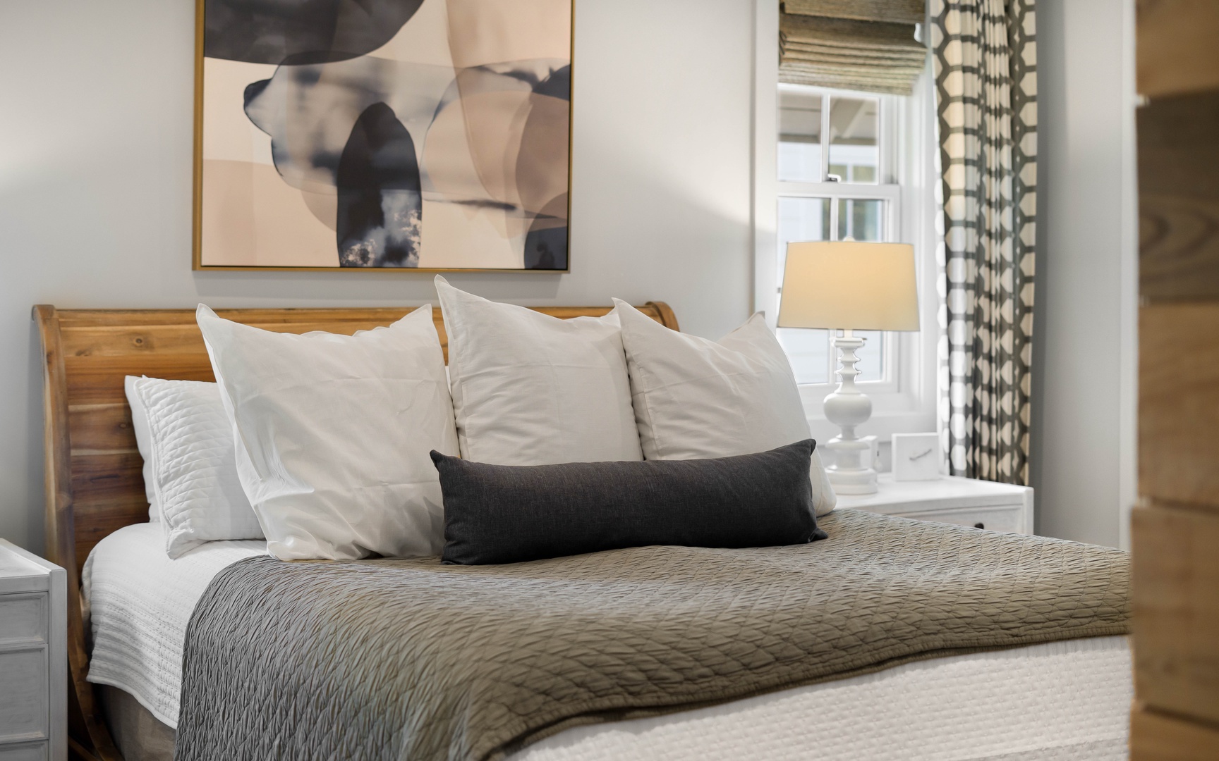 Sink into this beautifully appointed bedroom where soft linens and warm wood tones create your perfect retreat.