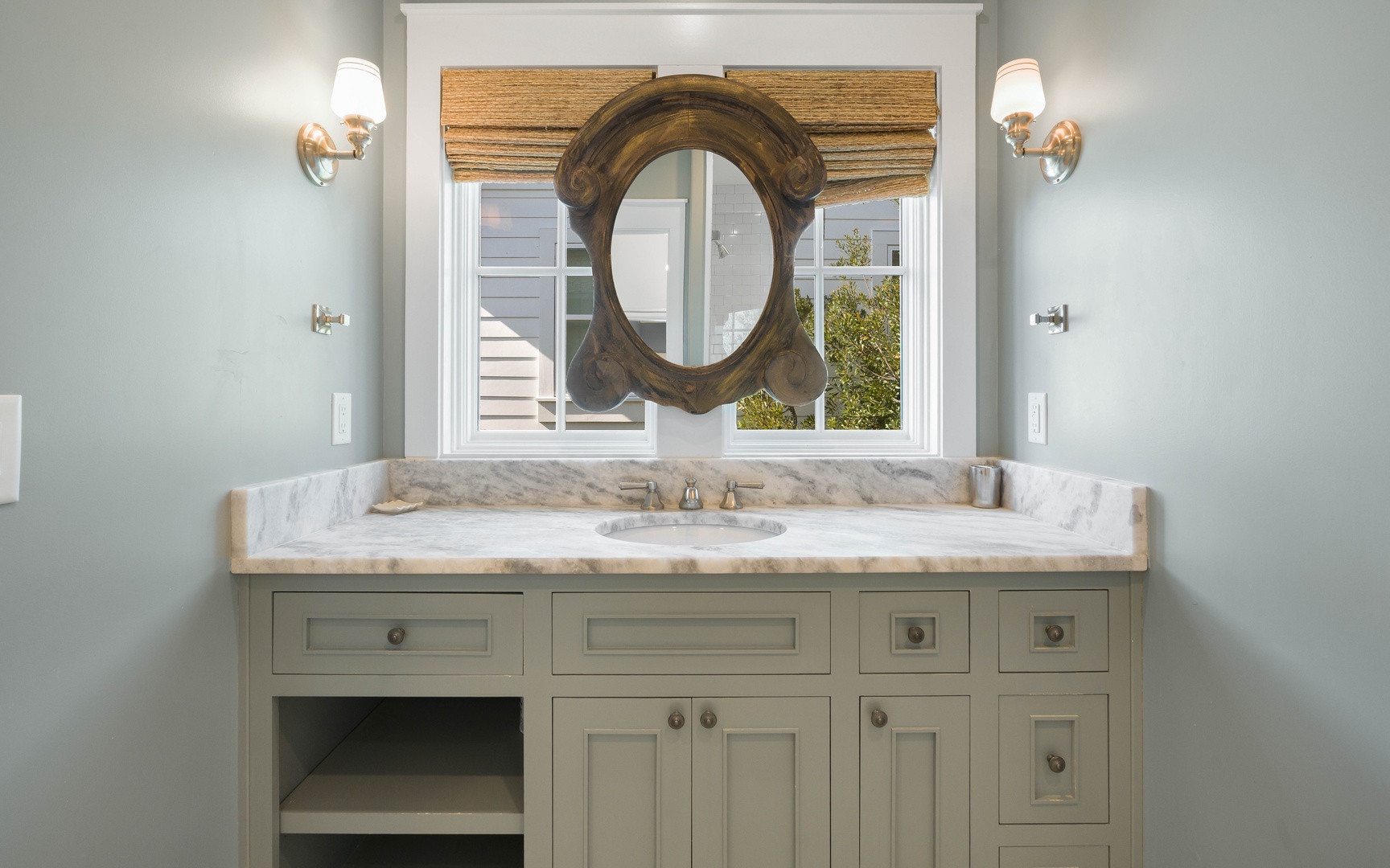 Unwind in your beautifully appointed bathroom featuring elegant marble countertops, stylish vanity storage, and warm ambient lighting.