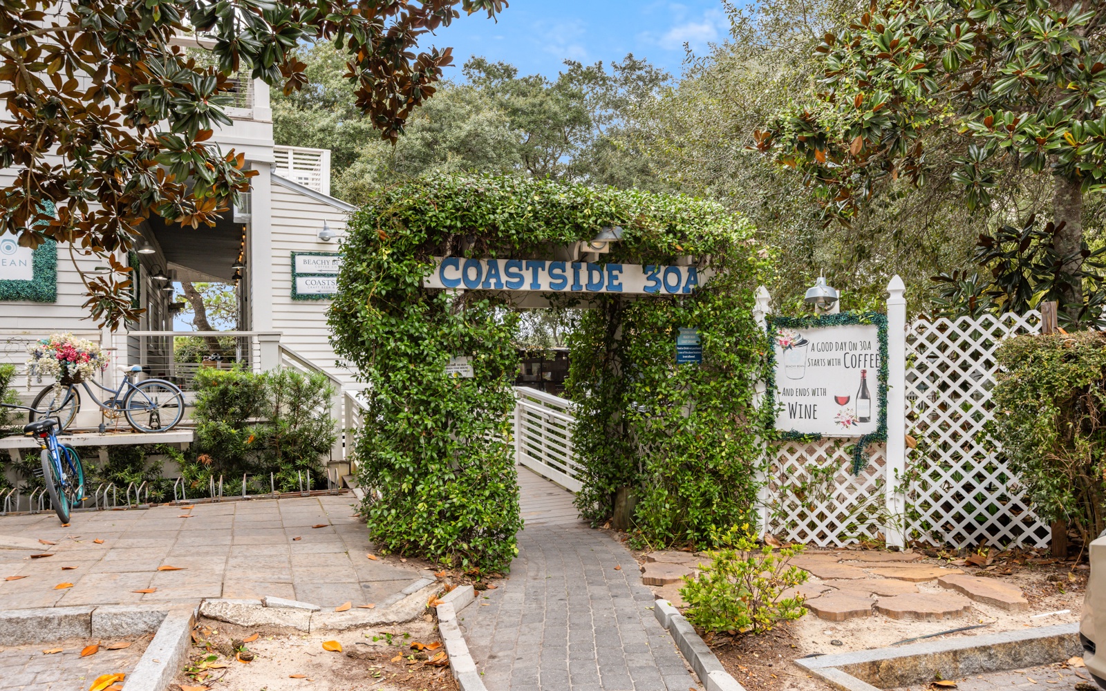 Property entrance featuring ivy-covered archway with 'Coastside 302' signage and charming coastal garden setting.