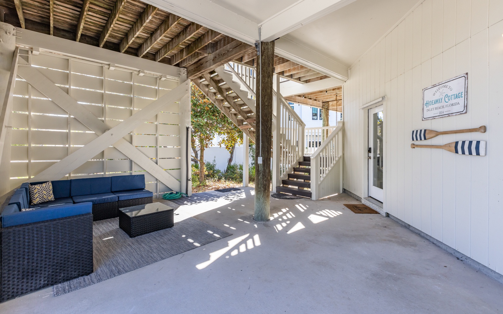 Your covered patio offers a perfect blend of comfort and coastal charm with blue seating and nautical touches.