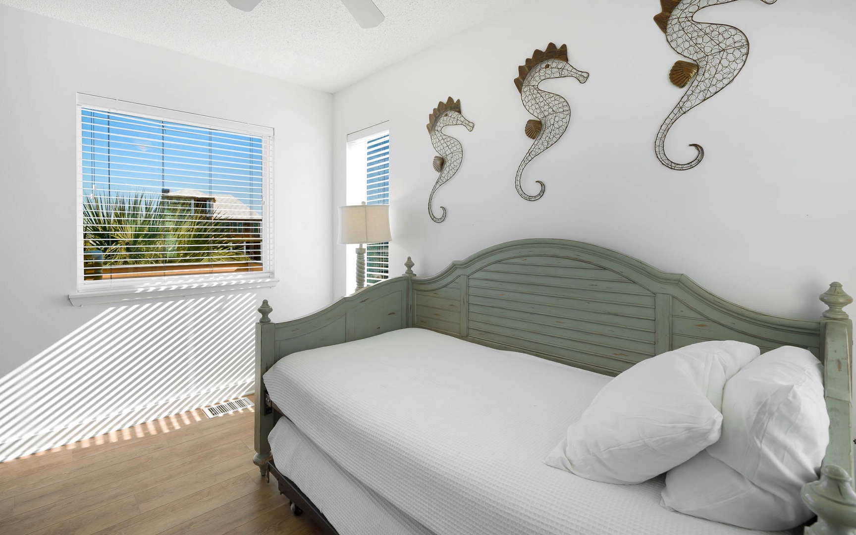 Your coastal bedroom features whimsical seahorse art and a charming sage-green headboard, with crisp linens awaiting your restful stay.