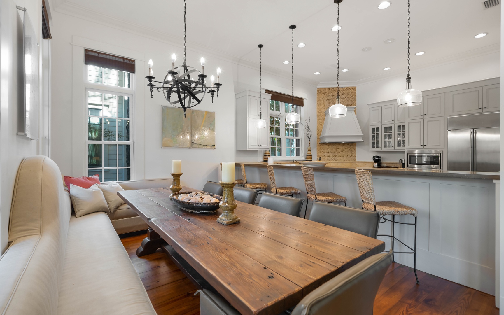 Gather around this rustic dining table while your chef creates magic in the open kitchen. Natural light streams through tall windows.