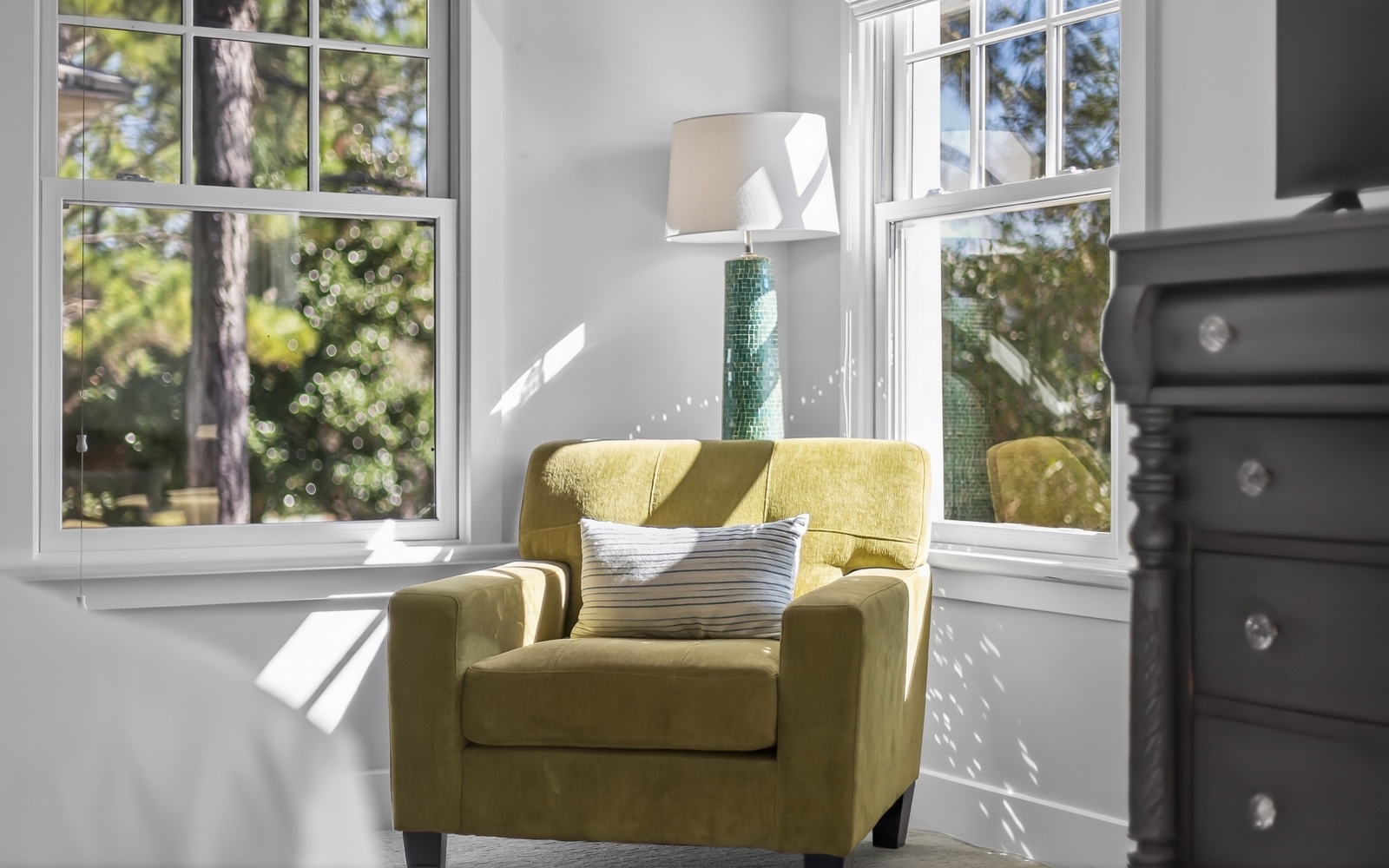Settle into your cozy reading nook with natural light streaming through large windows, perfect for morning coffee moments.