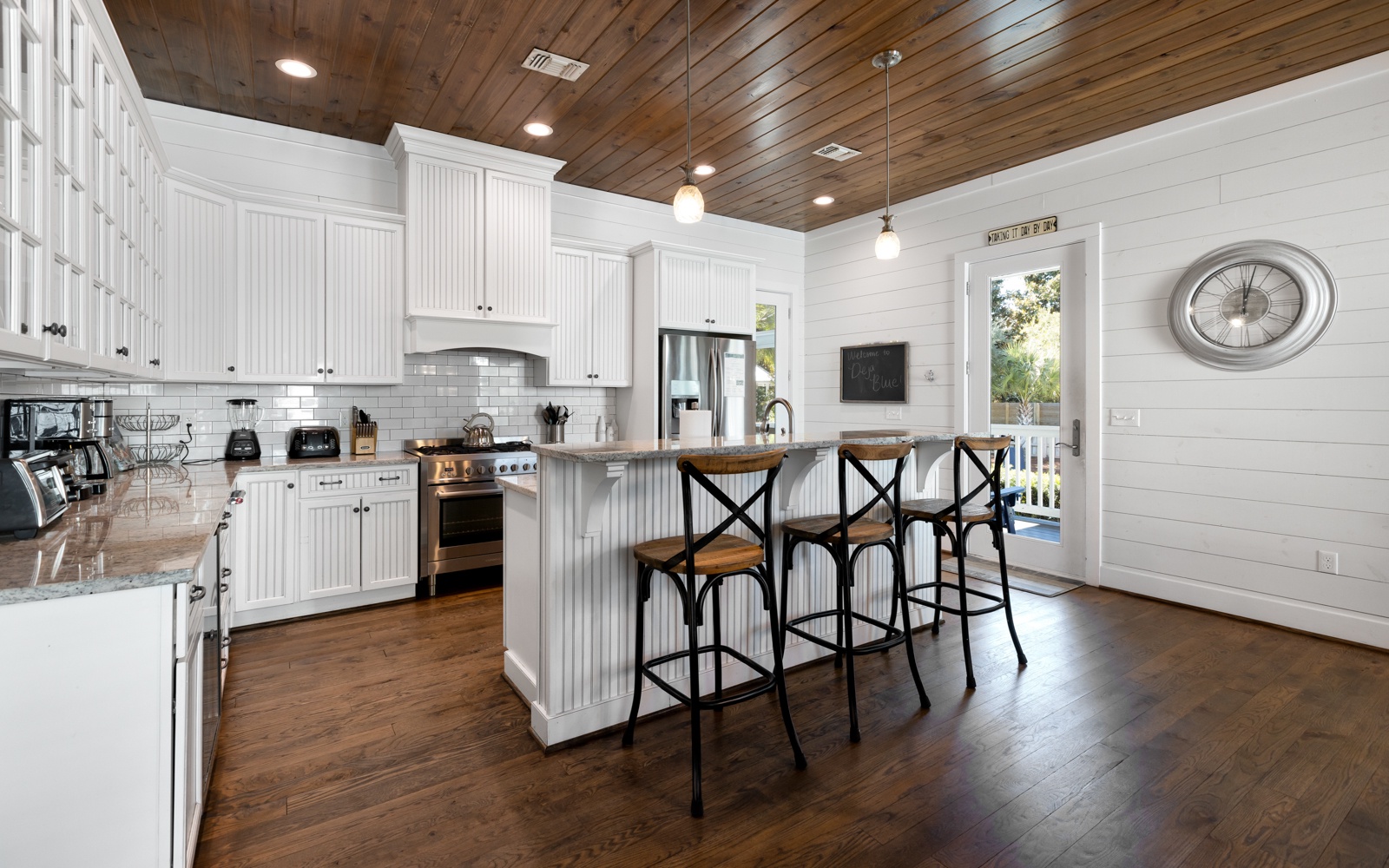 Your spacious farmhouse kitchen features stunning wood-plank ceilings, gleaming granite counters, and a breakfast bar perfect for morning coffee.