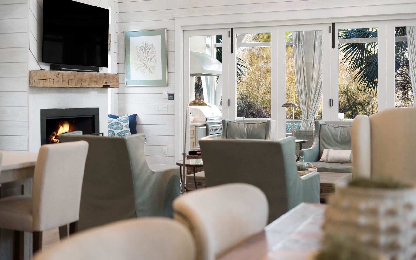 Relax in your bright living space with crackling fireplace, wall-mounted TV, and cozy seating overlooking tropical gardens.