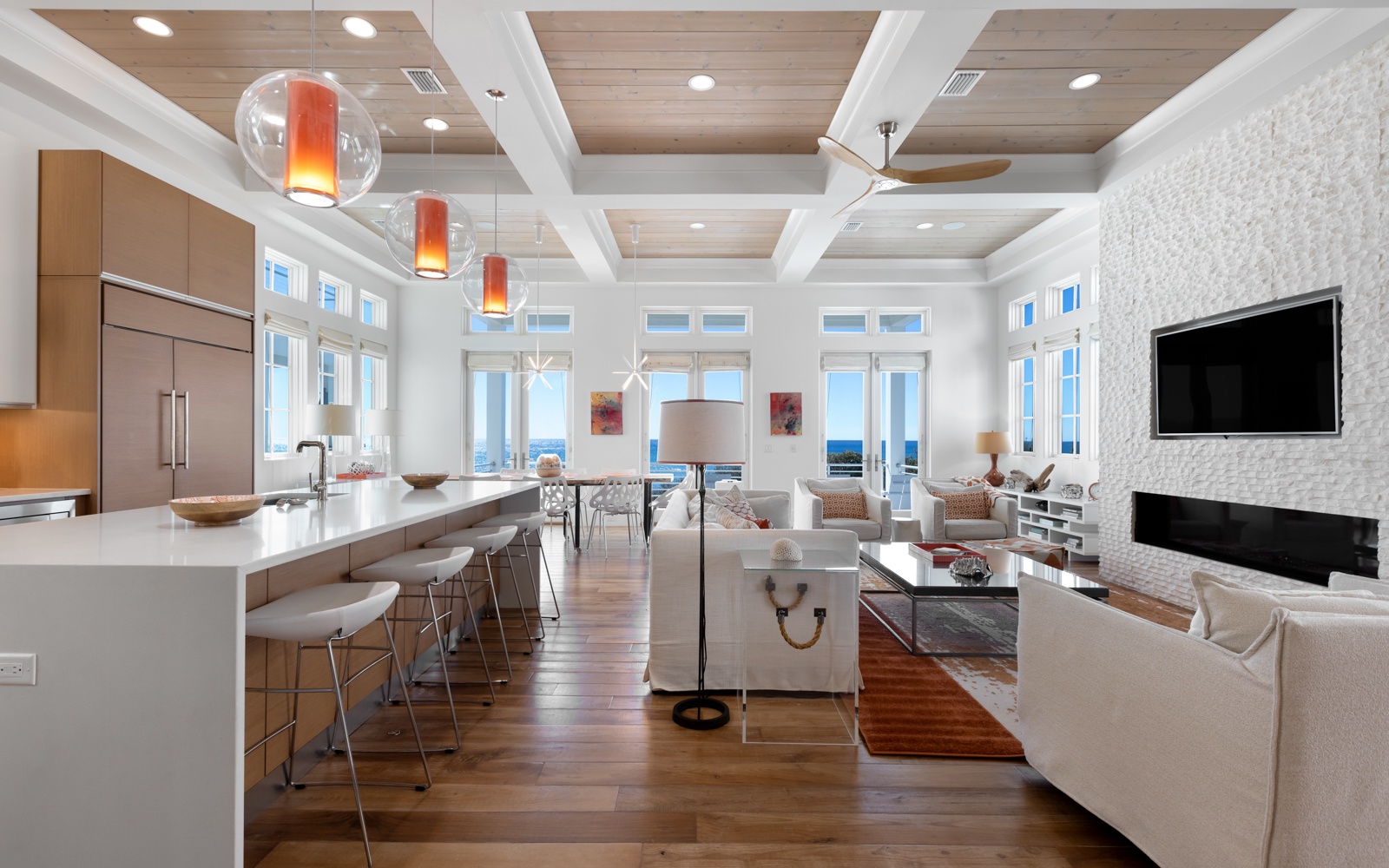 Relax in this stunning open-concept space where modern kitchen flows into elegant living area with fireplace and gulf views.