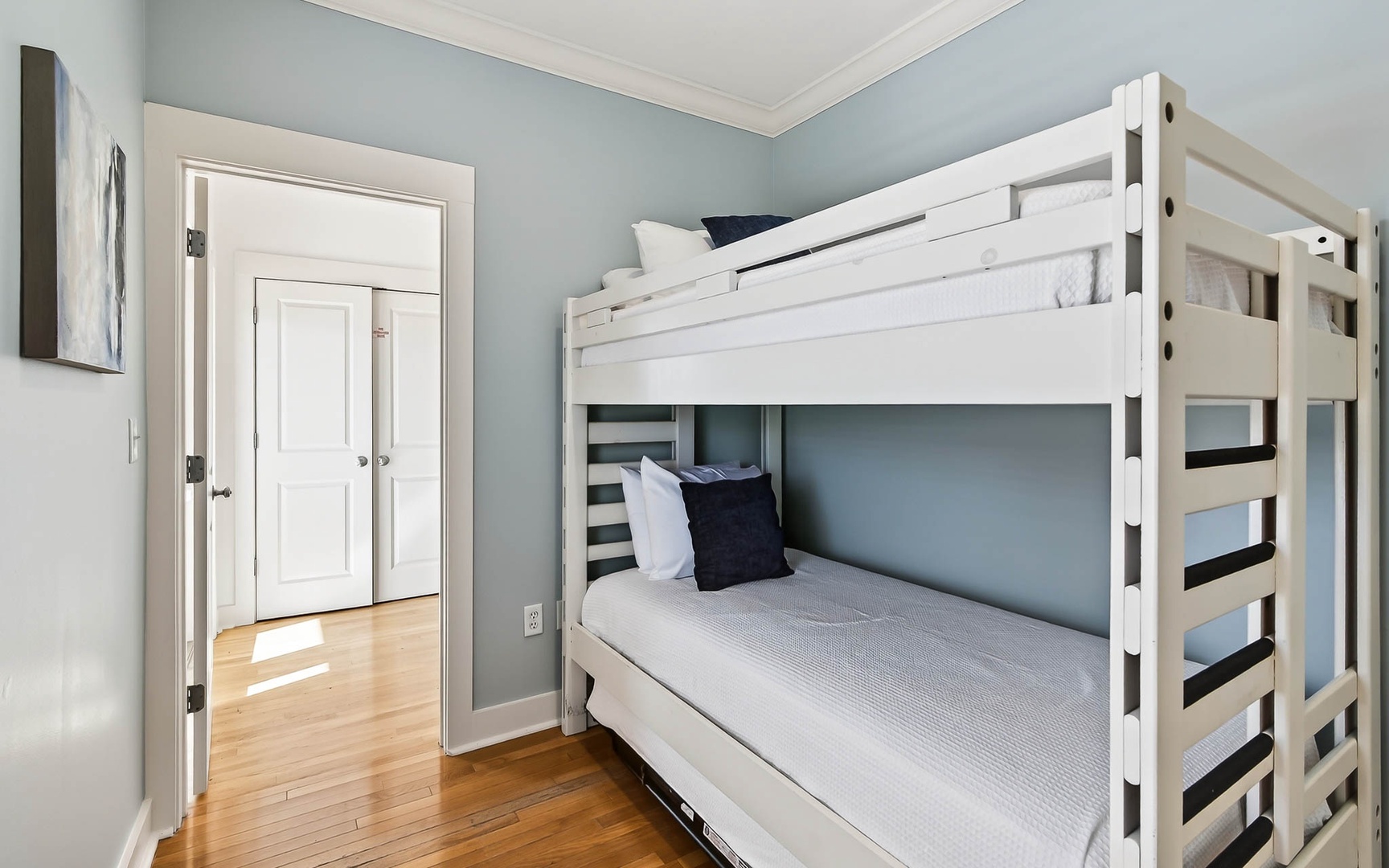Rest easy in your cozy bunk room with fresh linens and soothing blue walls creating the perfect retreat.
