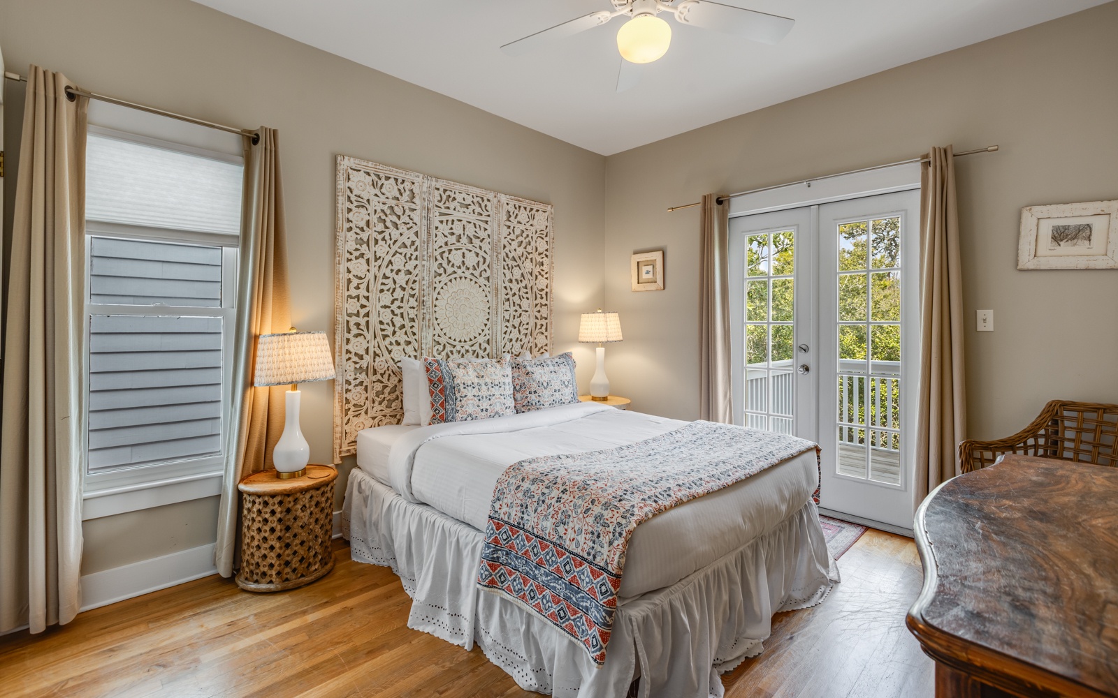 Wake up in this serene bedroom where intricate headboard artistry meets your private balcony views. Soft linens and warm lighting create your perfect retreat.