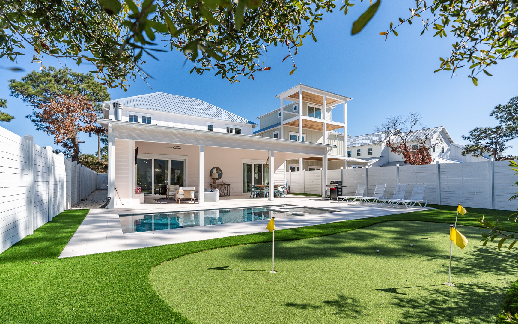 Modern coastal retreat with private pool, putting green, and covered patio for ultimate relaxation.