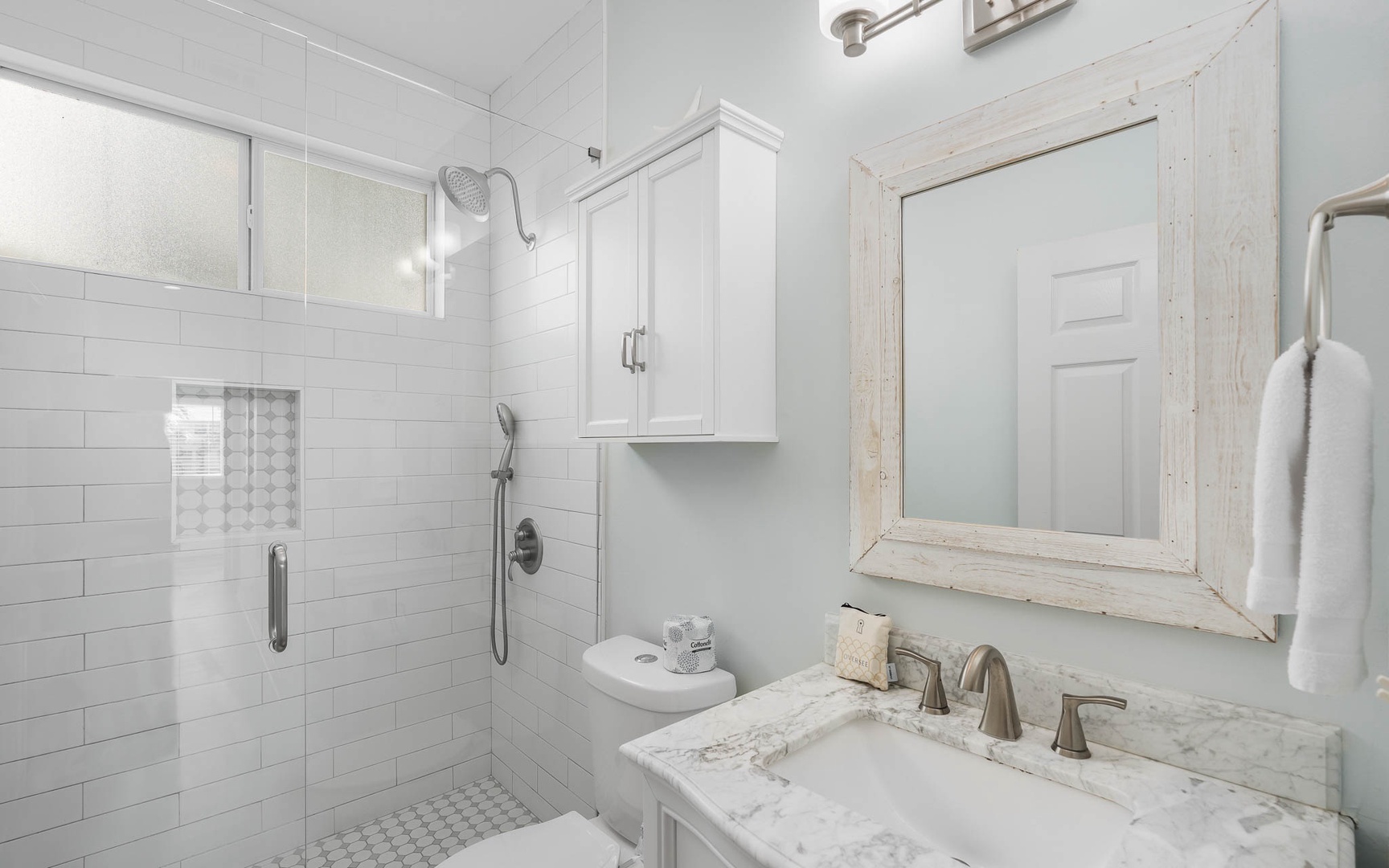 Refresh in your elegant bathroom featuring a spacious walk-in shower, marble vanity, and pristine white subway tile that creates a spa-like retreat.