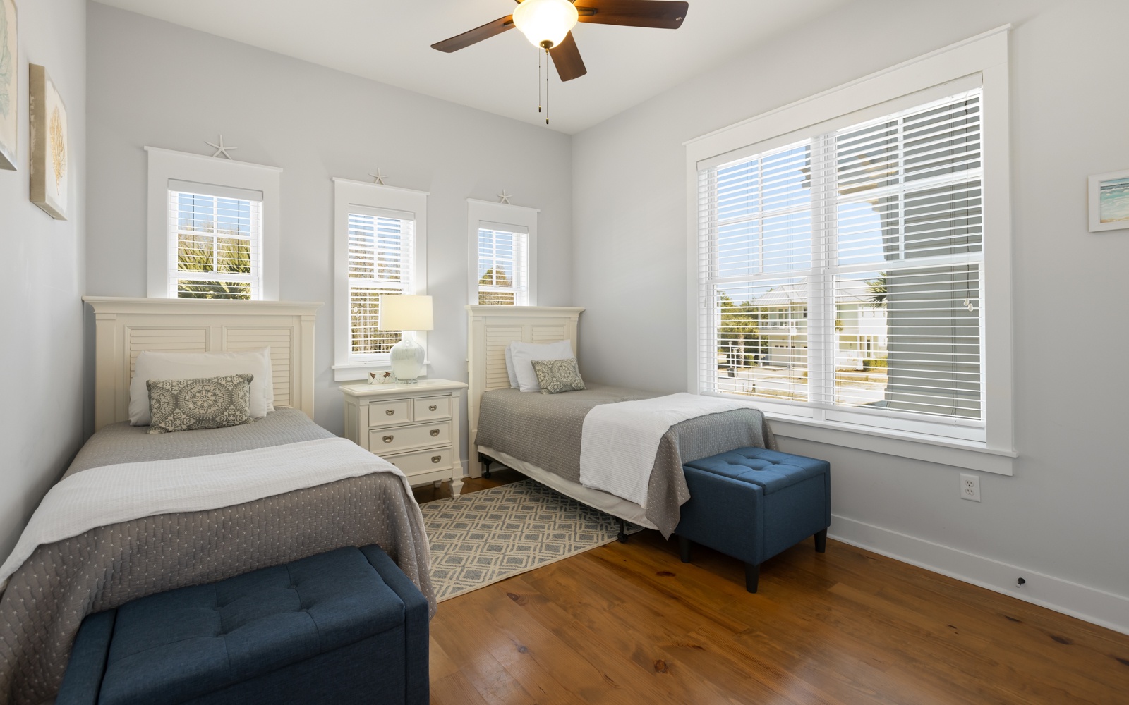 Rest peacefully in your bright twin bedroom with ceiling fan, hardwood floors, and cheerful windows welcoming natural light.