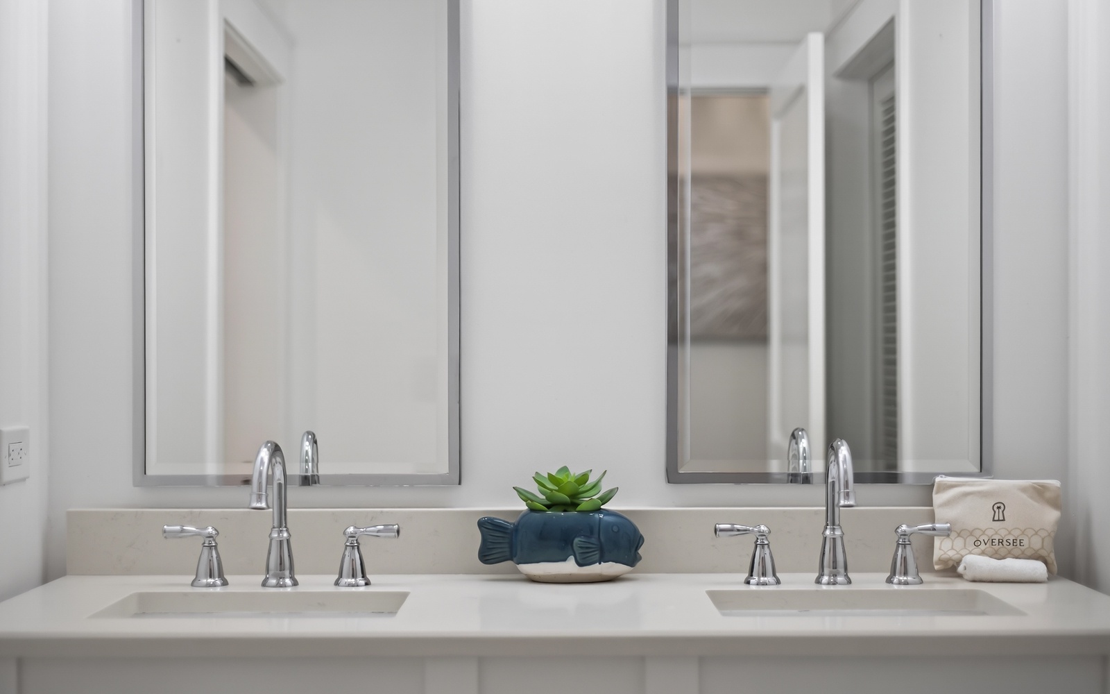 You'll love this elegant dual-sink vanity with soft lighting and thoughtful touches like fresh greenery to start your mornings right.