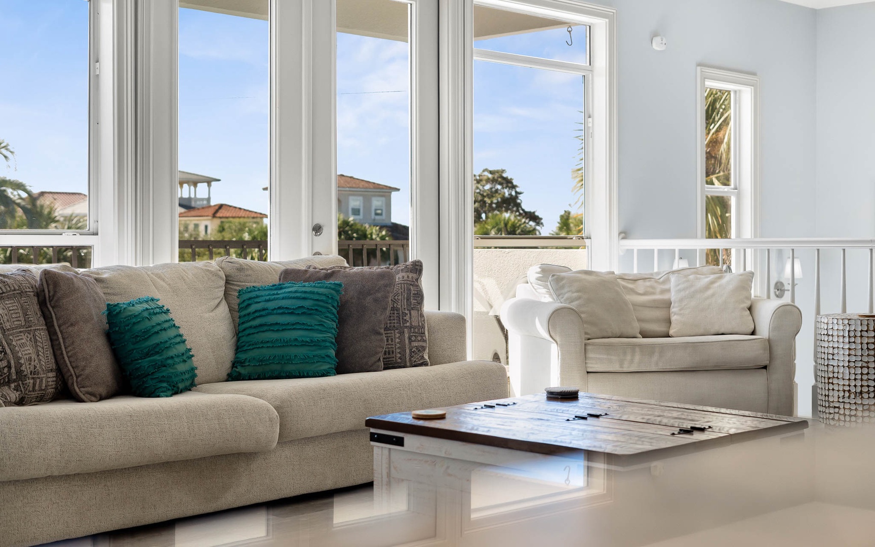 Sink into plush sofas where natural light floods your bright living space through floor-to-ceiling windows showcasing charming neighborhood views.