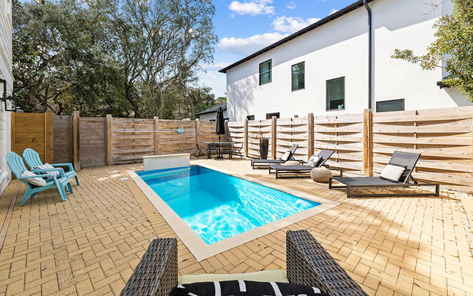 Dive into your private oasis with crystal-clear pool waters surrounded by comfortable loungers on warm brick pavers.