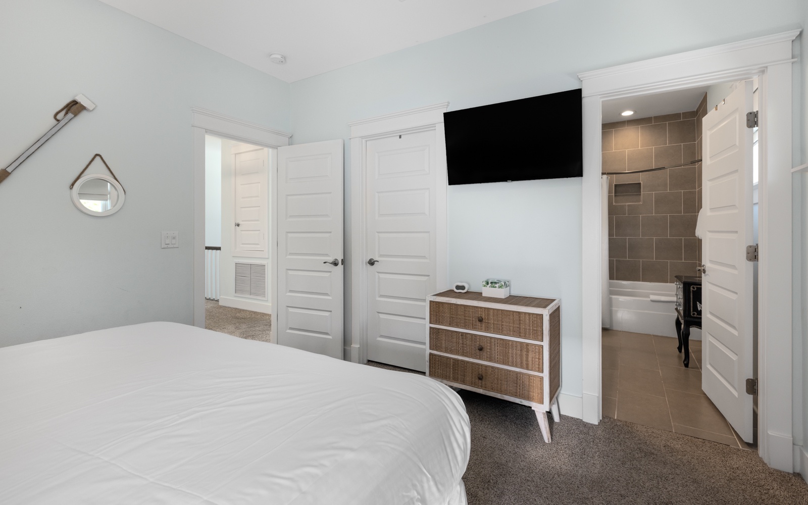Your master bedroom features a cozy bed, wall-mounted TV, and stylish dresser, with an ensuite bathroom for ultimate comfort.