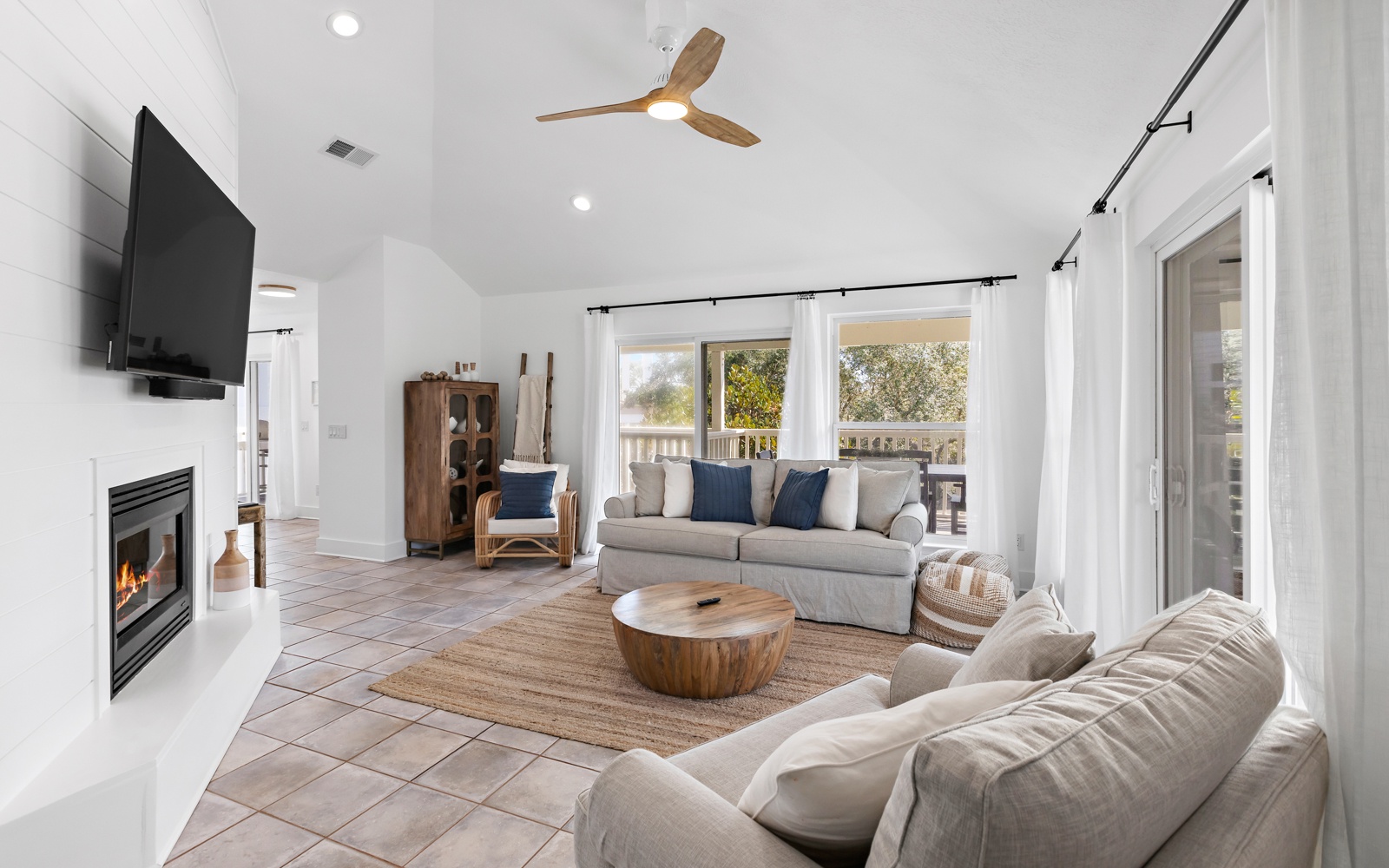 Unwind in your bright living space with cozy seating by the fireplace and natural light streaming through large windows.