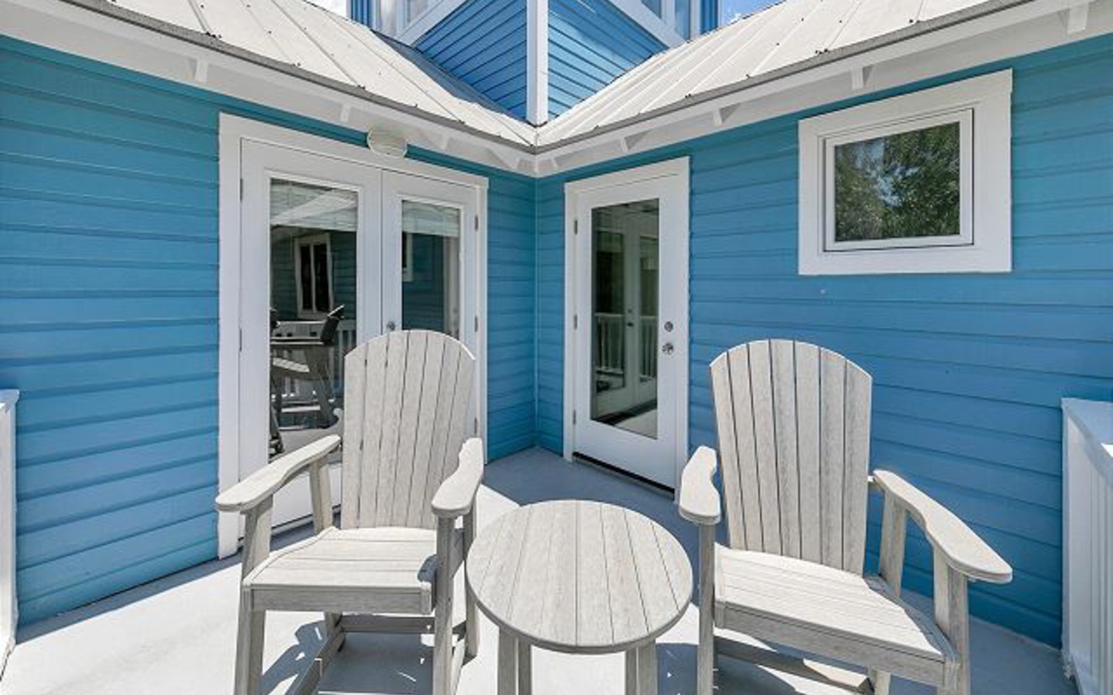 Unwind on your private balcony with comfy Adirondack chairs, perfect for morning coffee or evening relaxation in this charming coastal-inspired setting.