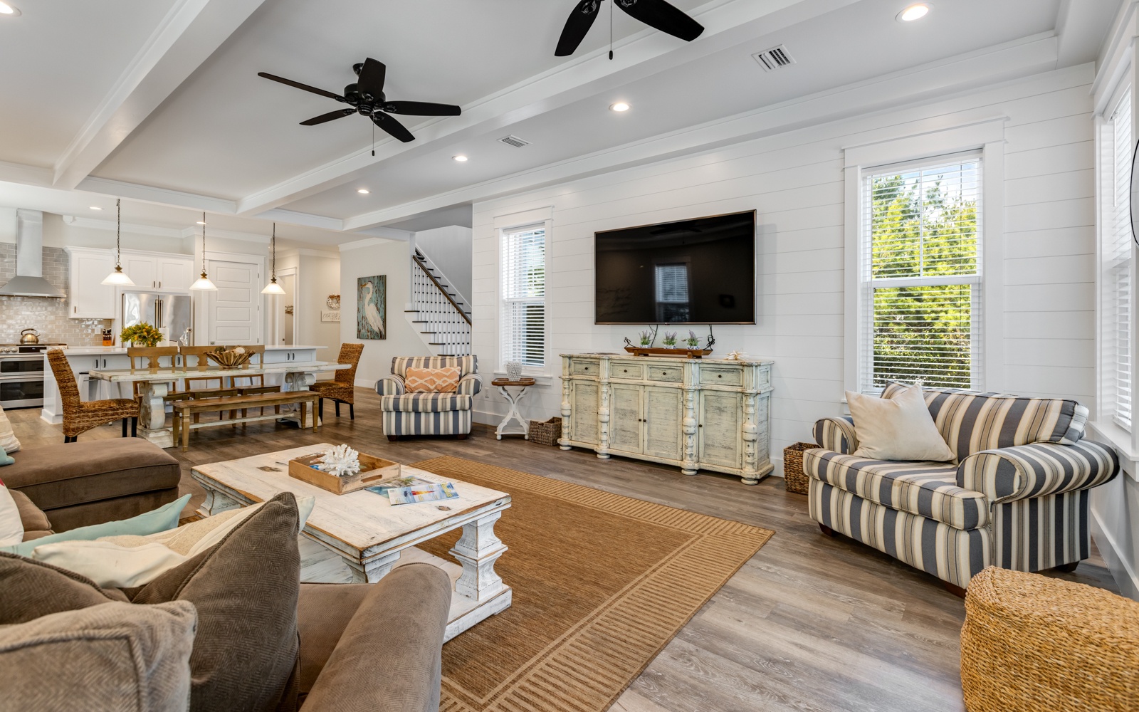 Relax in your spacious coastal living room with soaring ceilings, cozy seating, and natural light streaming through large windows.