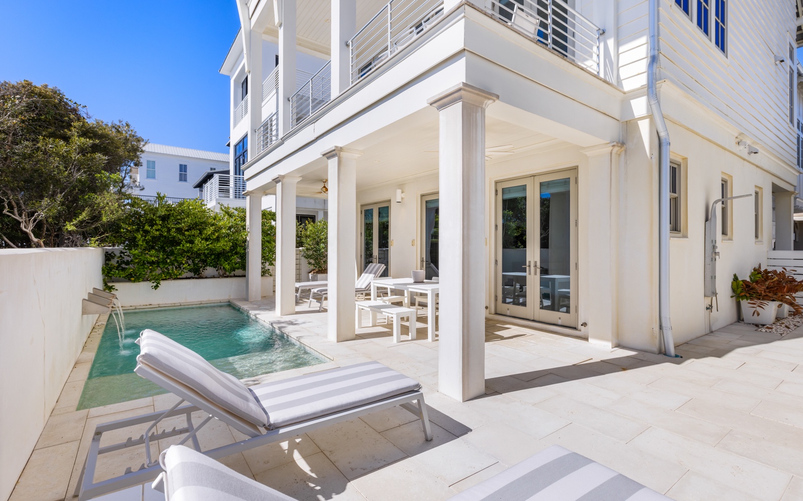 Your private pool awaits just steps from your door, with pristine white loungers perfect for soaking up sunshine.