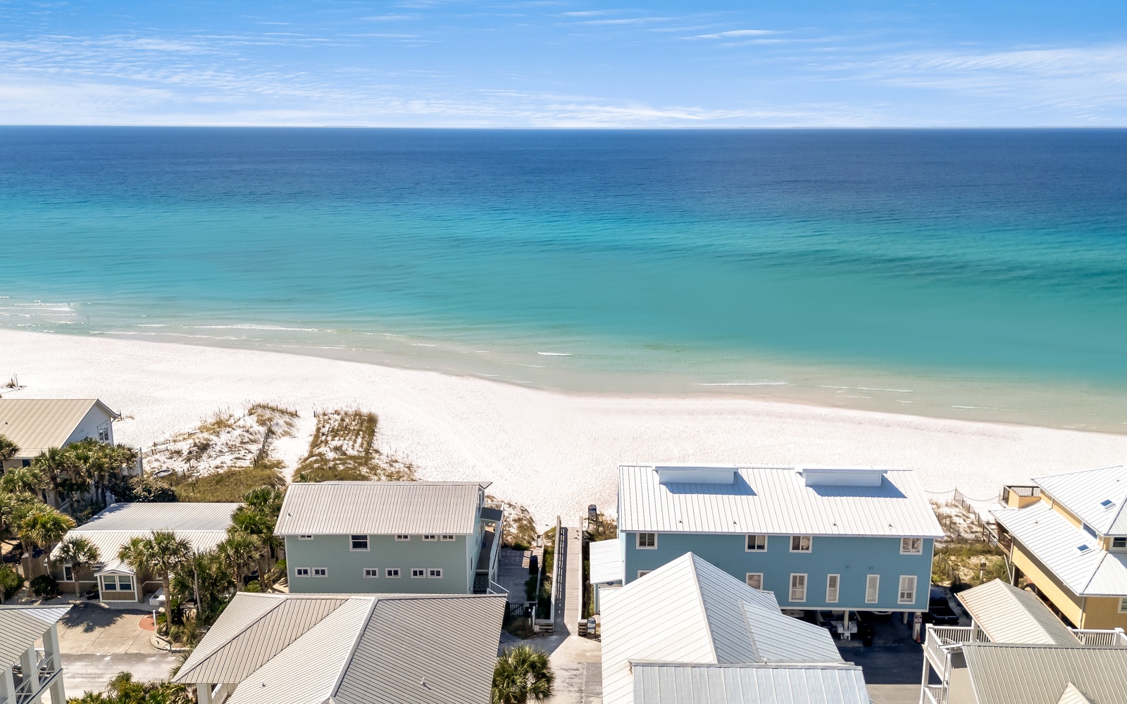 Pristine beachfront location with crystal-clear turquoise waters and powdery white sand just steps from coastal vacation homes.